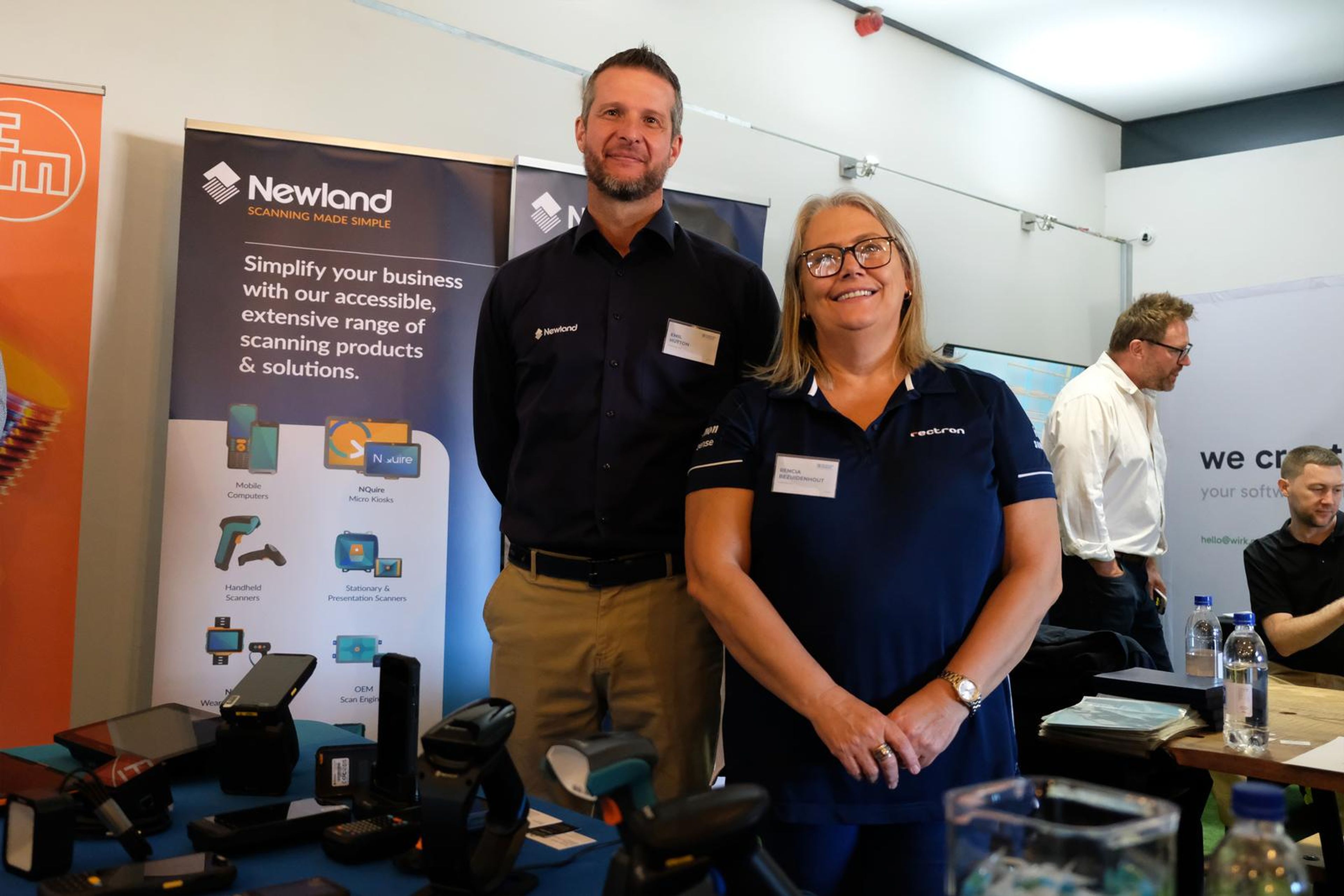 Two Newland AIDC team members smiling at their stand