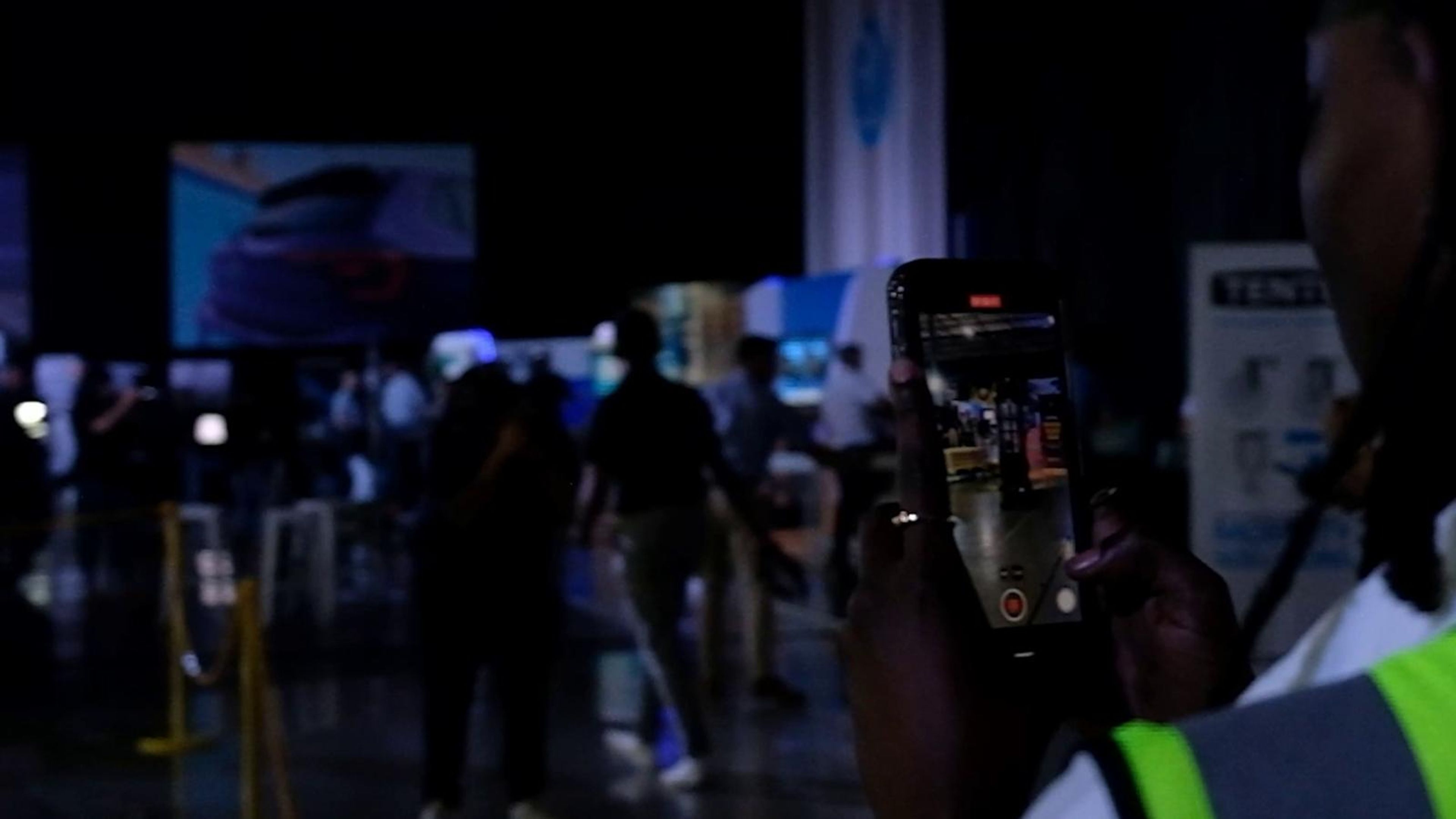 Visitors filming the stands on a phone as the hall fills