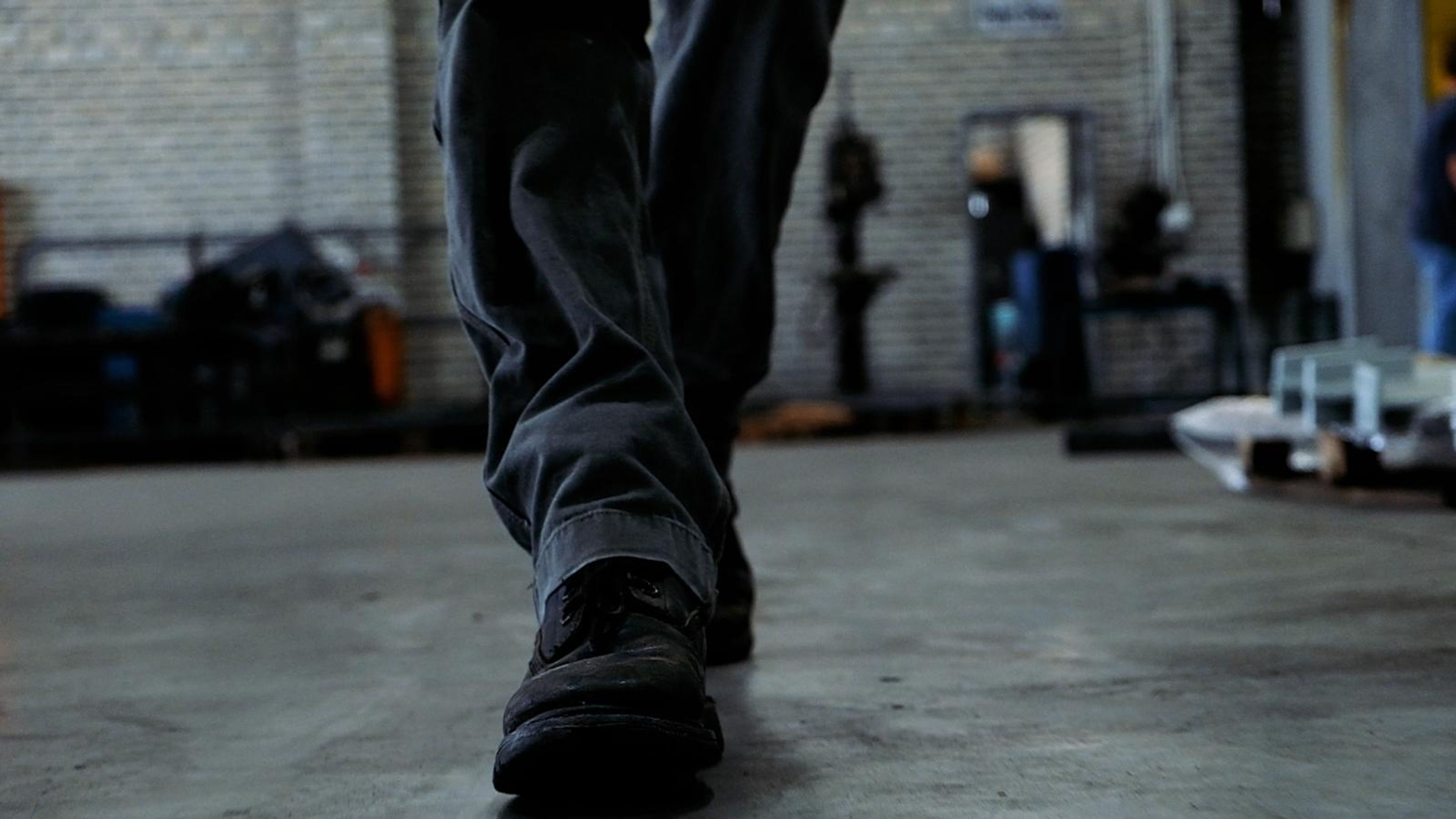 Worker's boots walking across the workshop floor