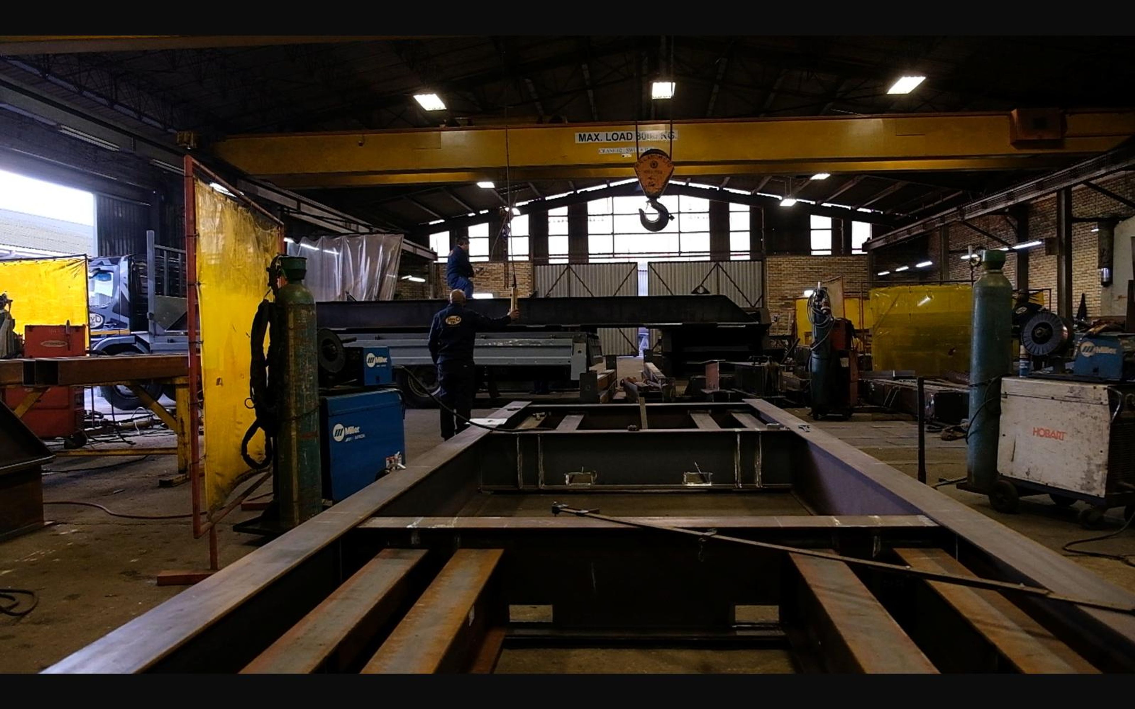 Steel chassis frame being built under the overhead crane