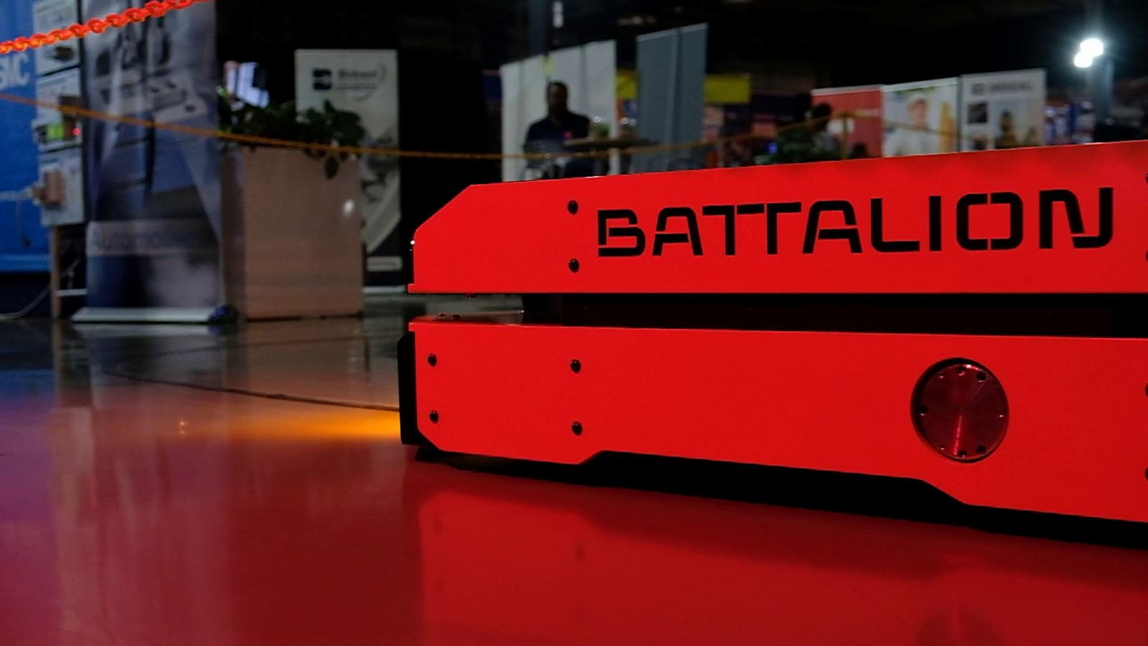 Small autonomous robot with cyan lights beside the S4 Integration stand