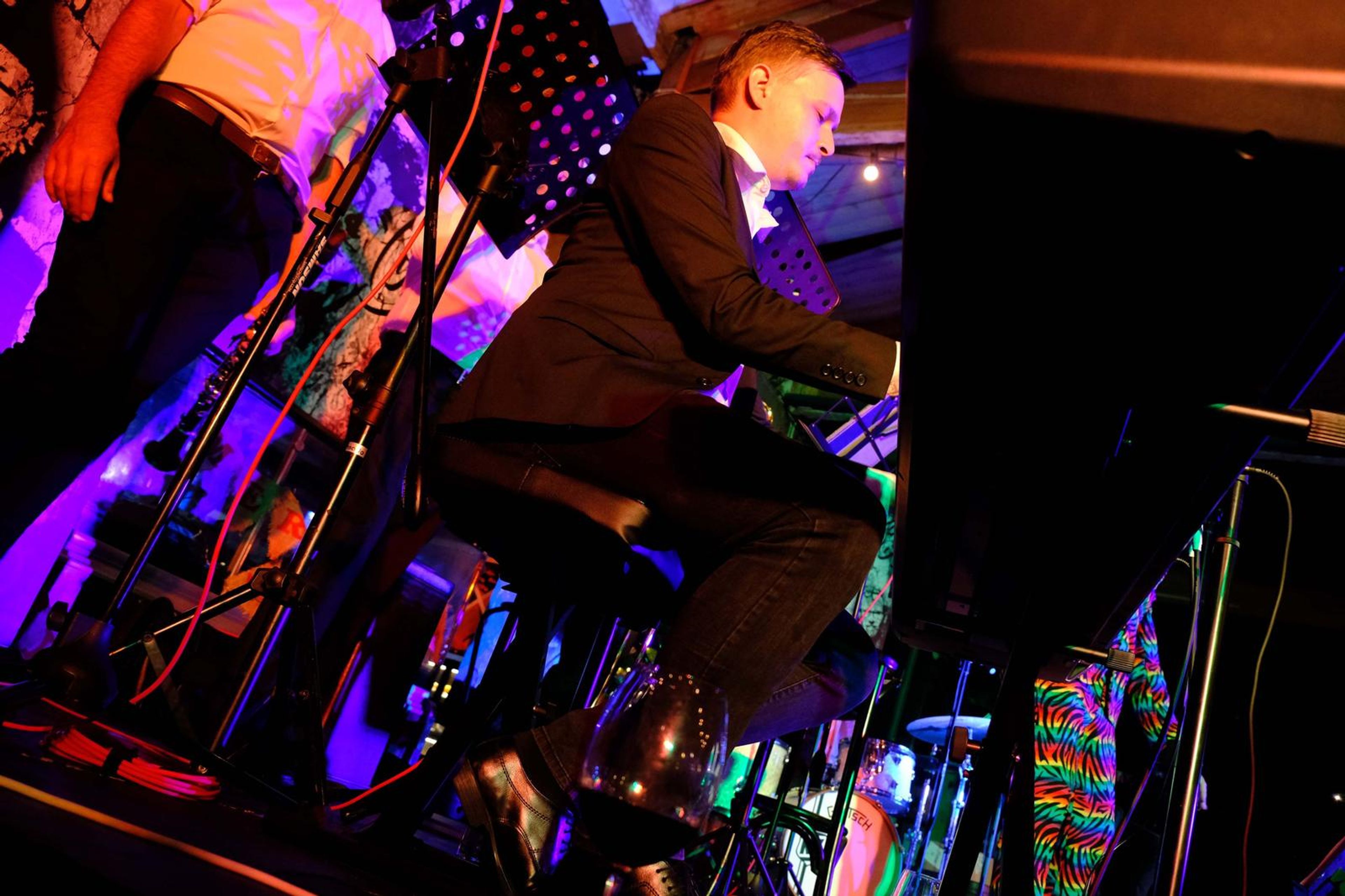 Pianist in a suit playing beside brightly patterned trousers