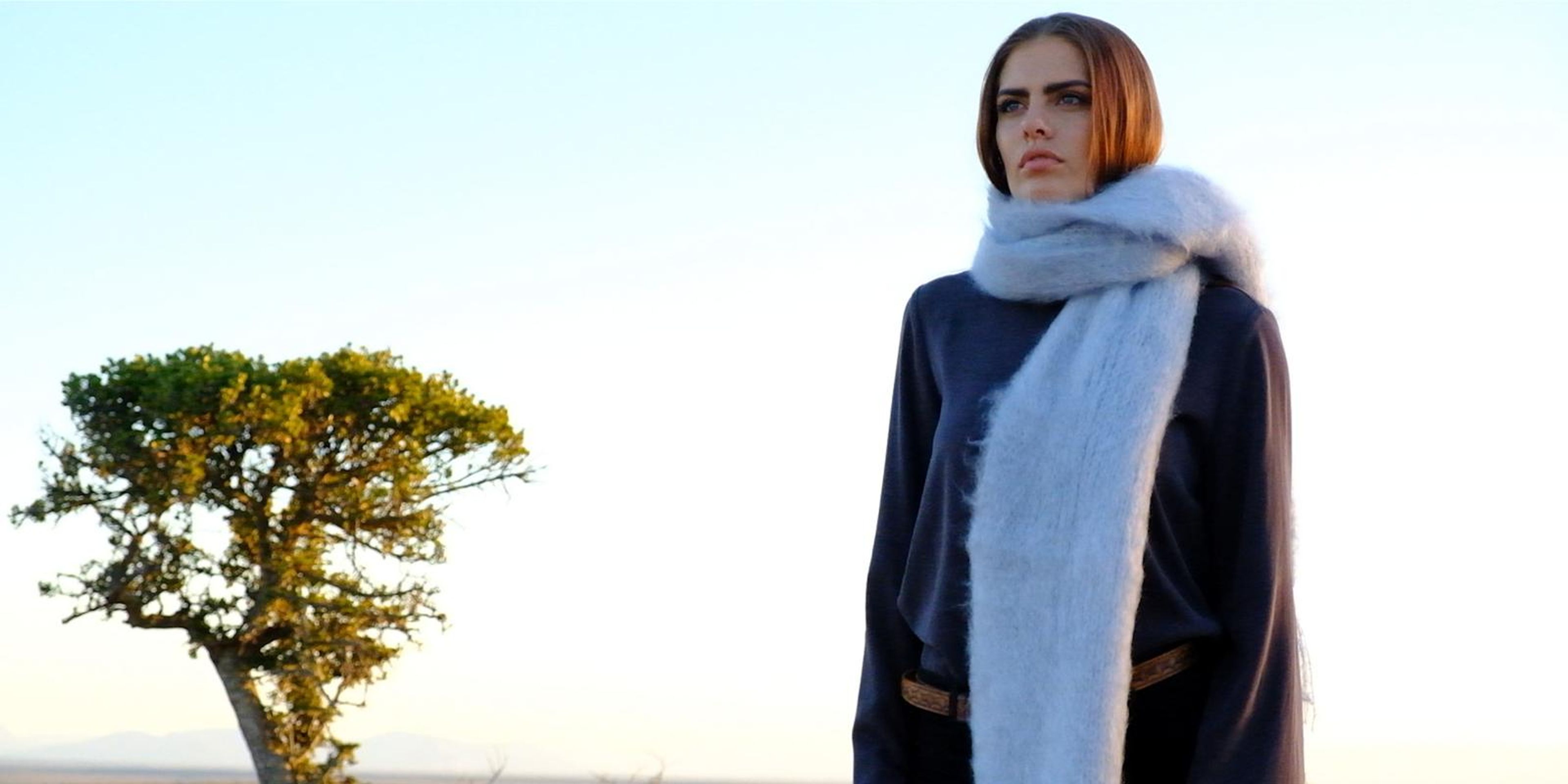 Model in a chunky grey mohair scarf beside a quiver tree