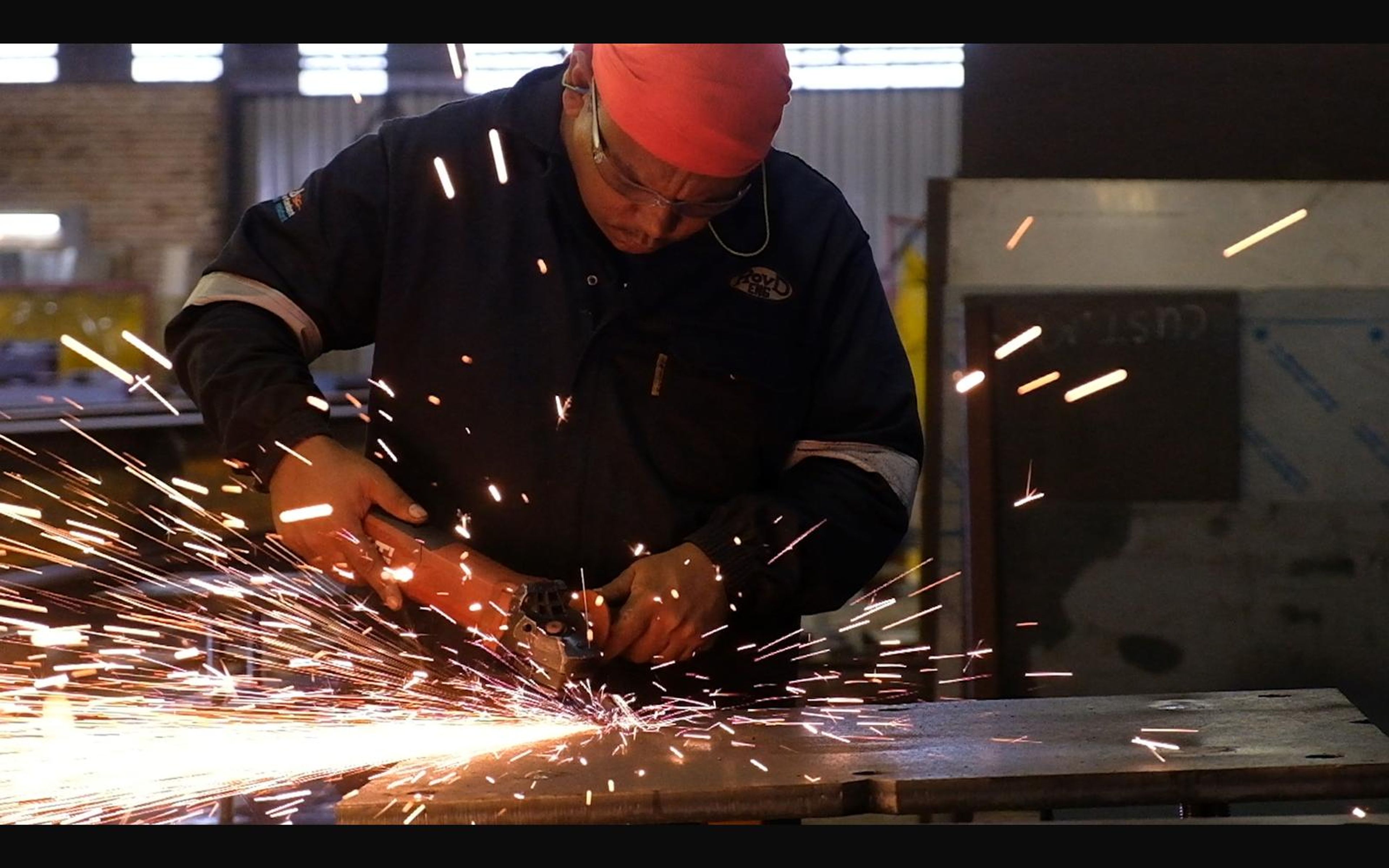 Fabricator grinding steel with sparks flying