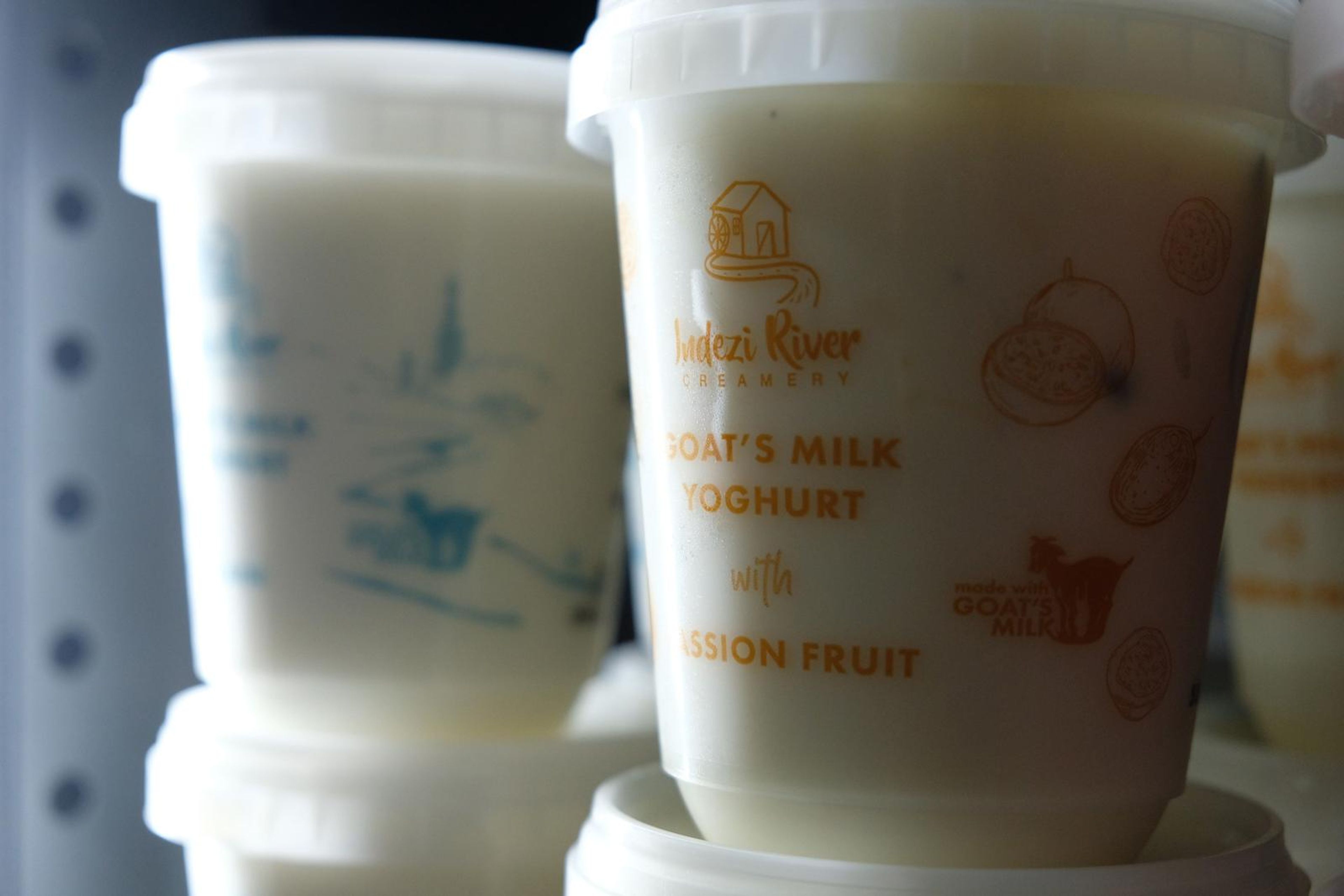 Tubs of goat's milk yoghurt in lemon and strawberry flavours