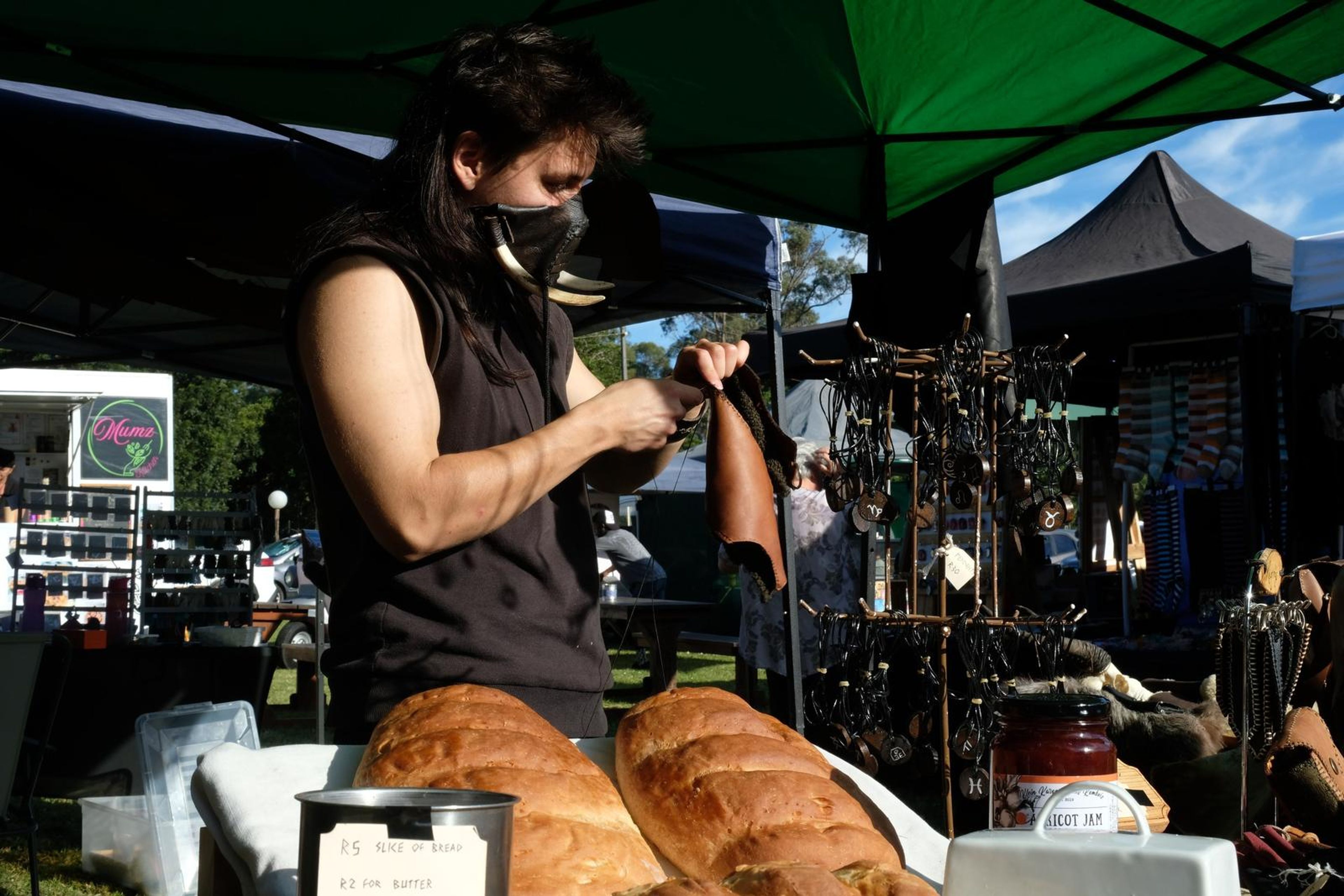 Juuks maker working at the stall with leather goods and bread in the foreground