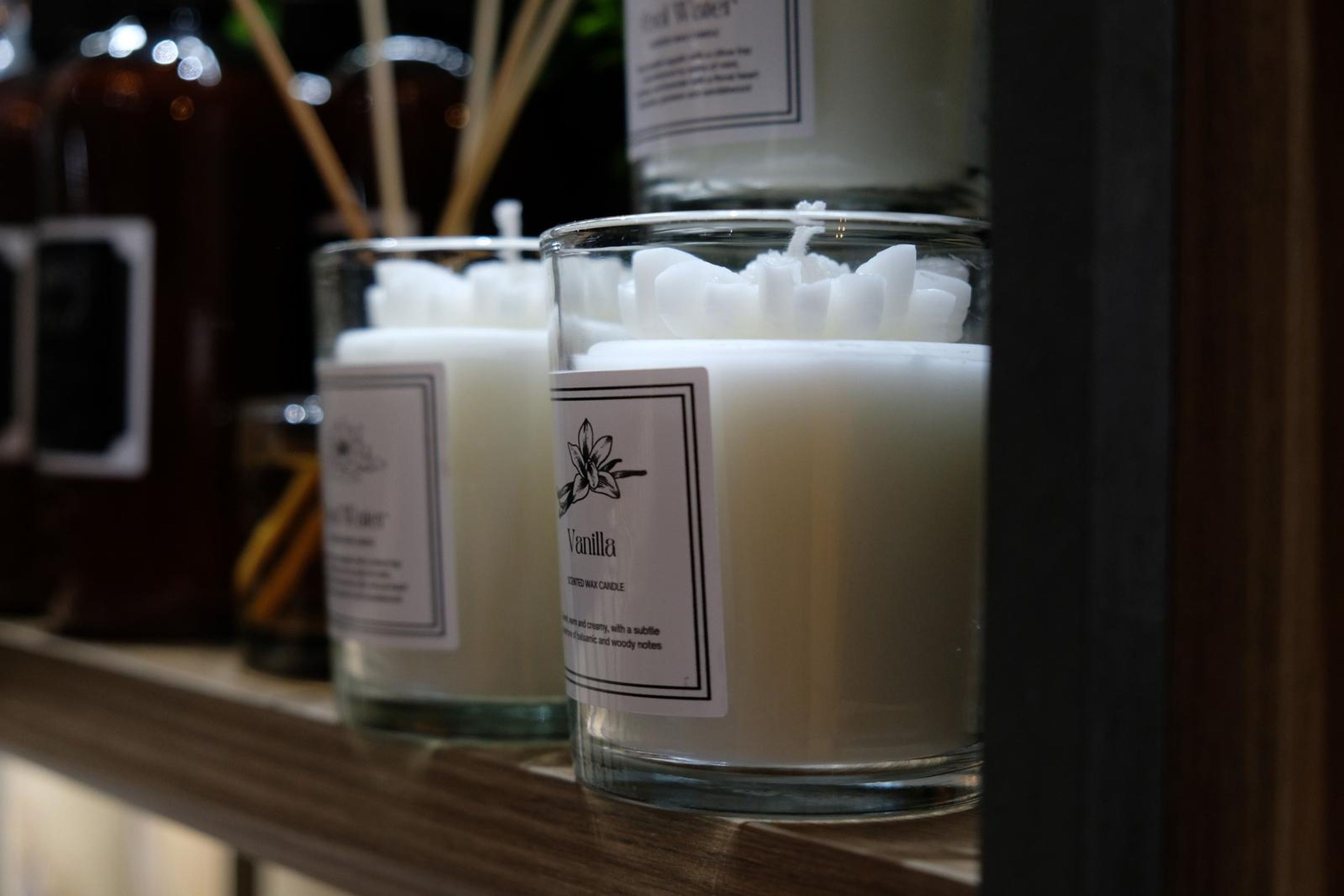 Candles and reed diffusers on a wicker shelf