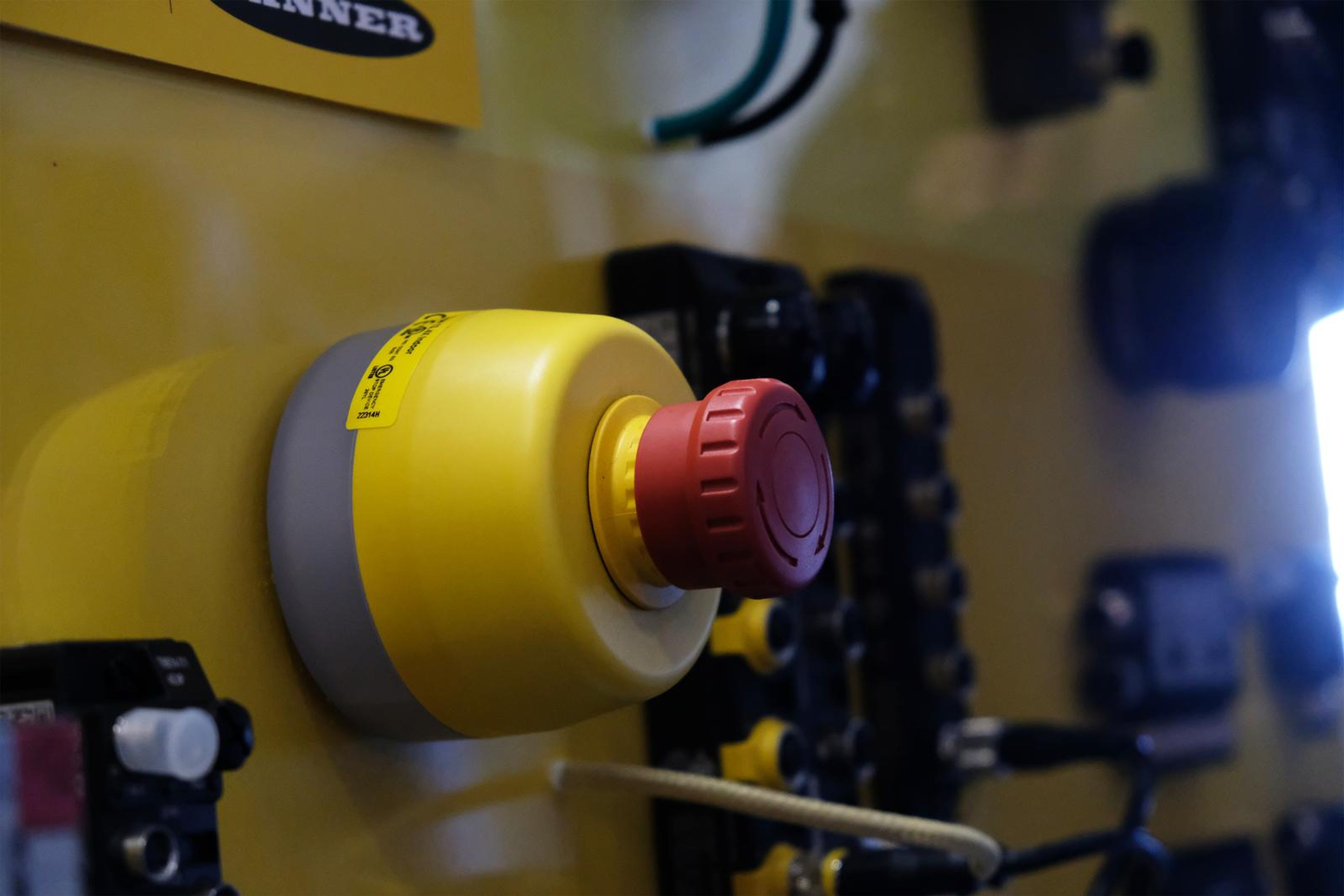 Close view of a yellow emergency stop button on a Turck panel