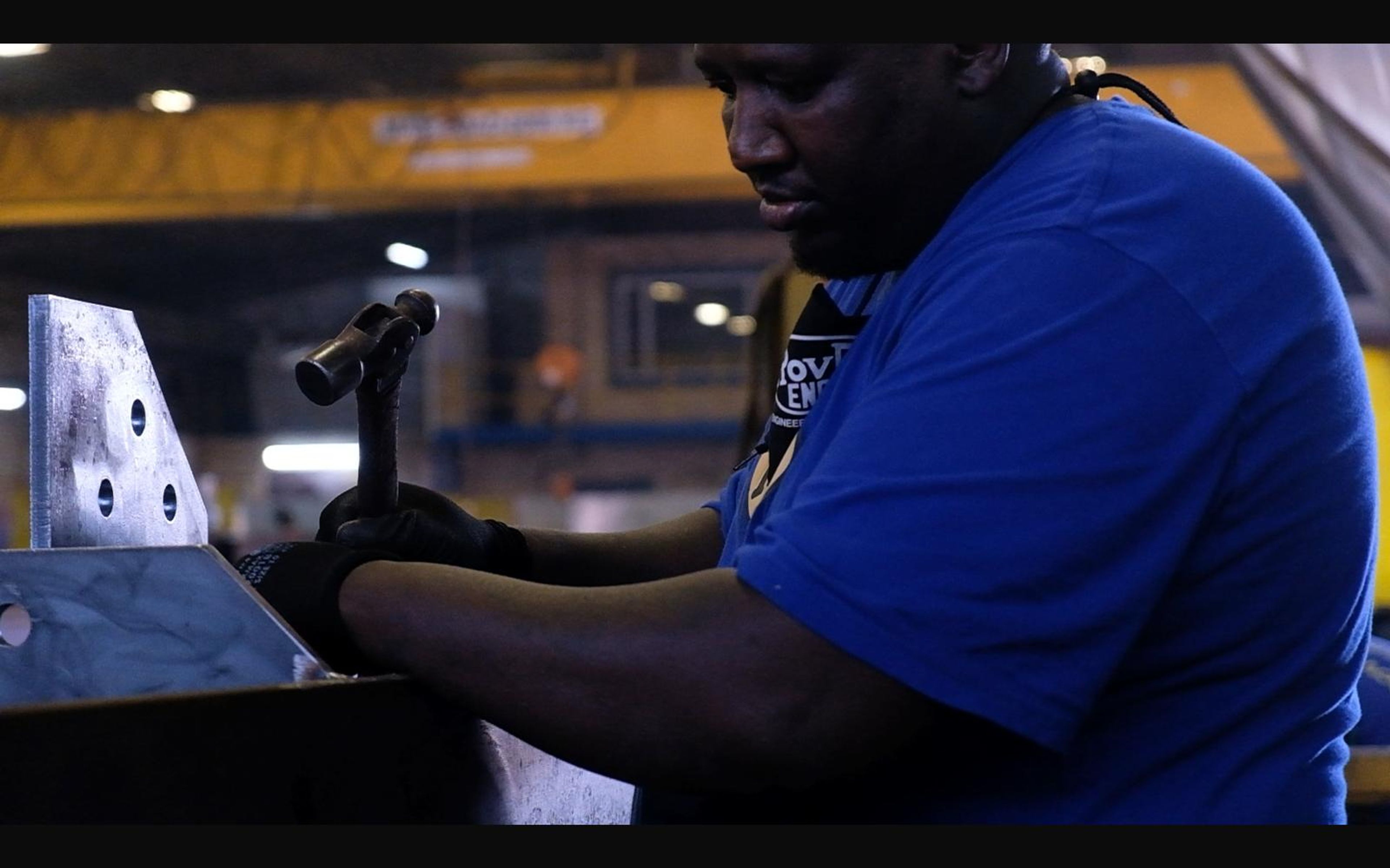 Fabricator fitting a steel bracket