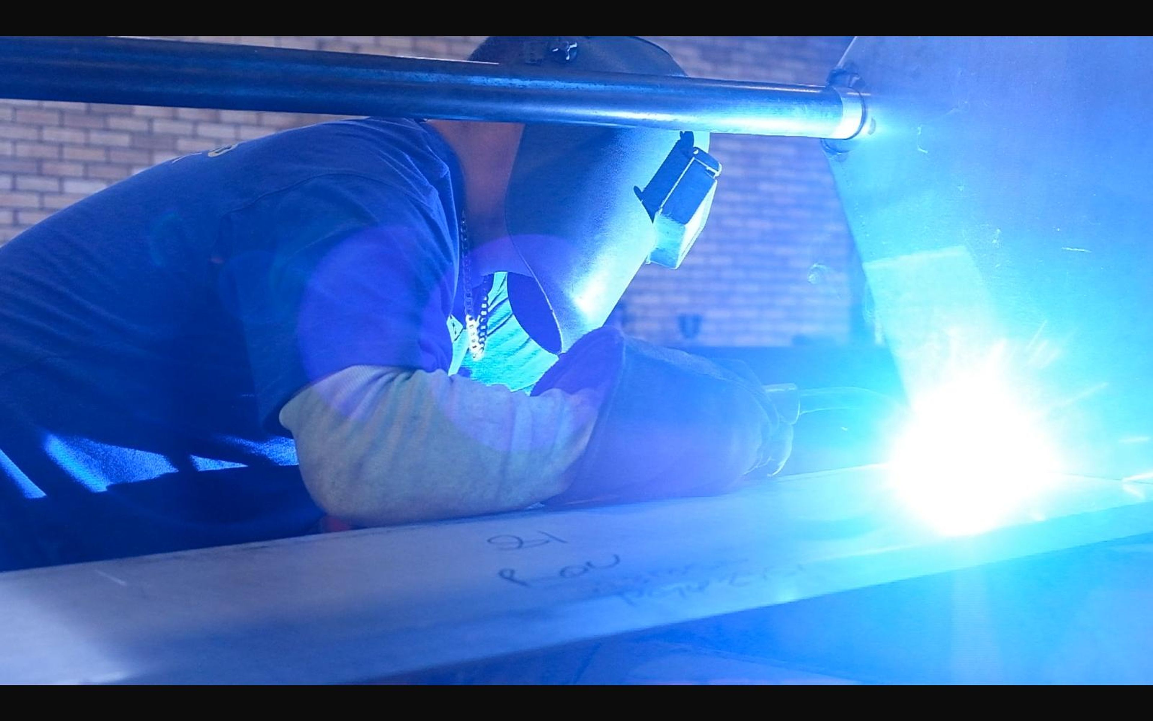 Welder with a bright arc under a helmet
