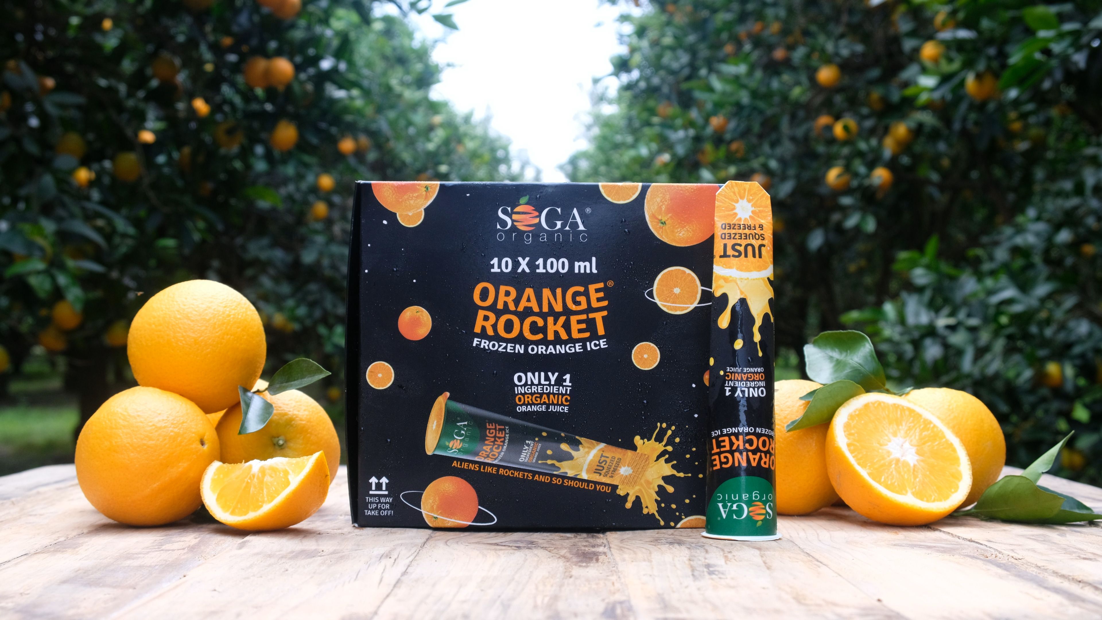 Orange Rocket box on a wooden table among oranges in an orchard