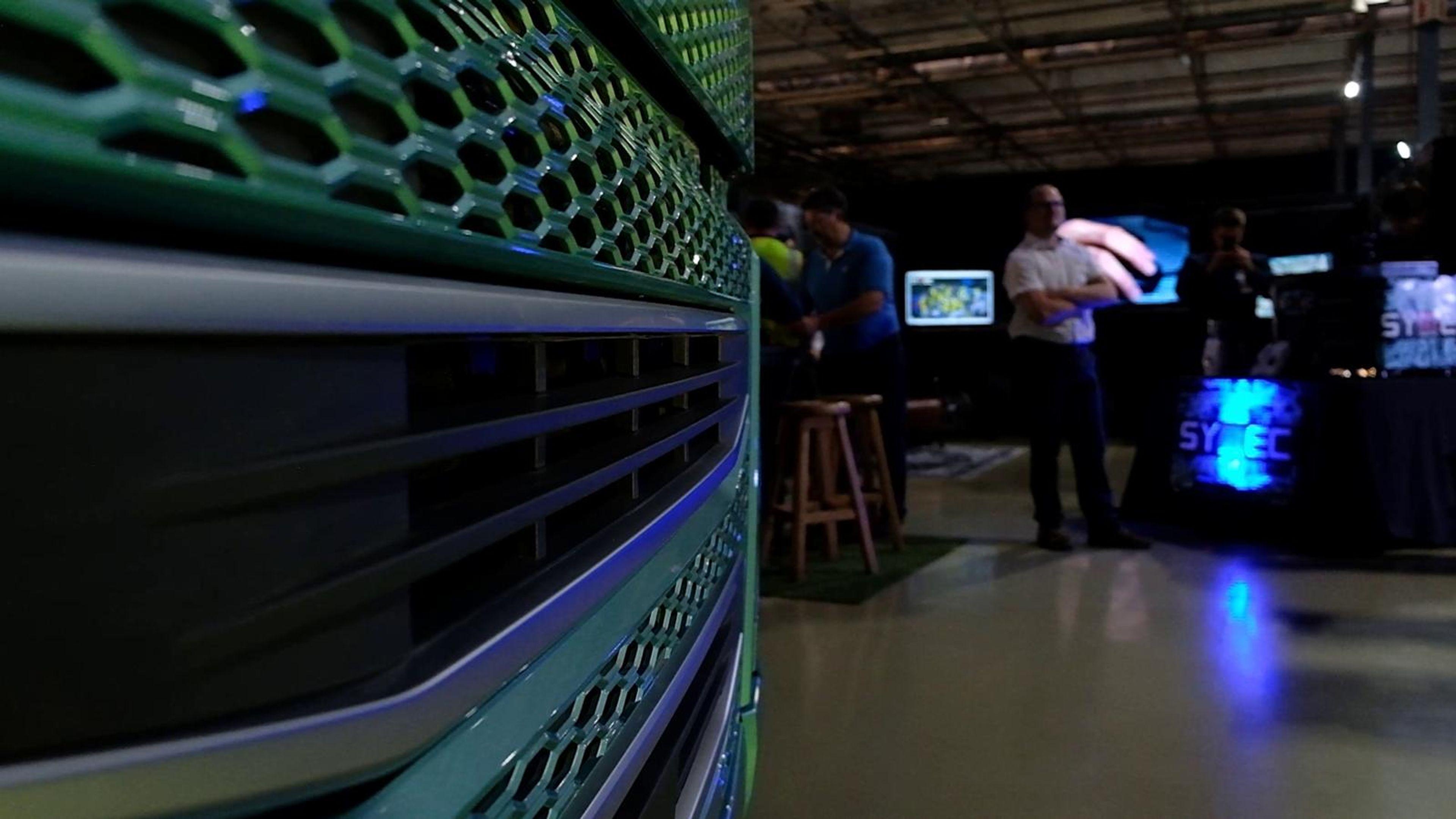 Large screen showing a glowing 3D model of a production line