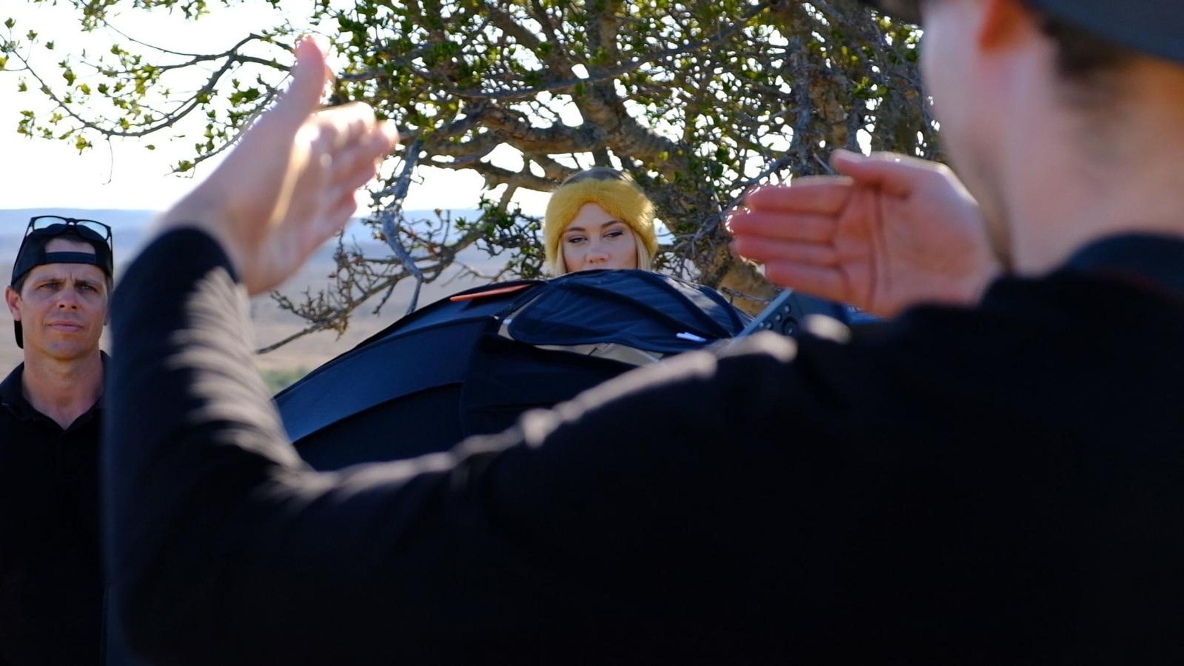 Crew member directing the model beneath a softbox