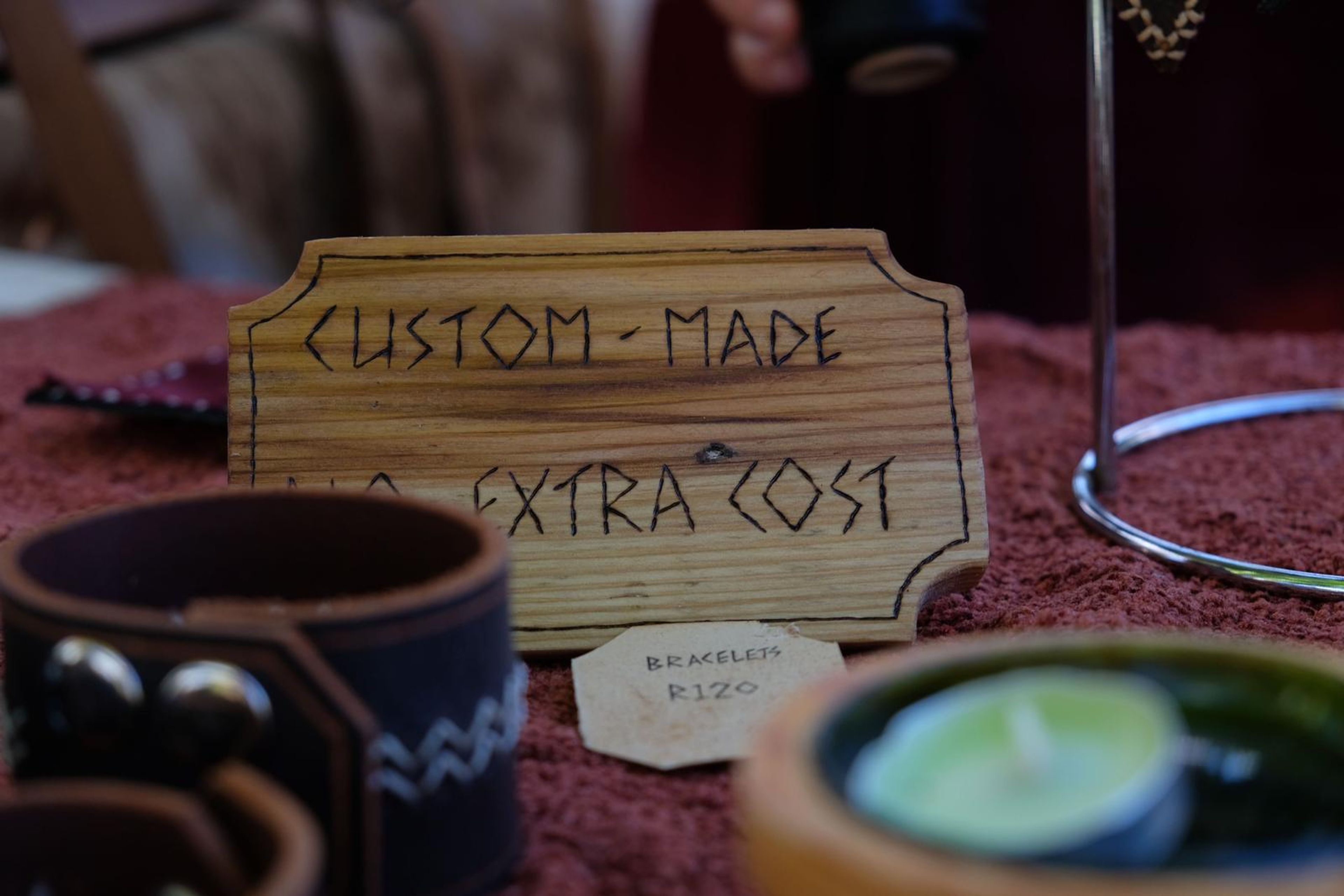 Dark leather cuffs with hand-stitched patterns on red cloth
