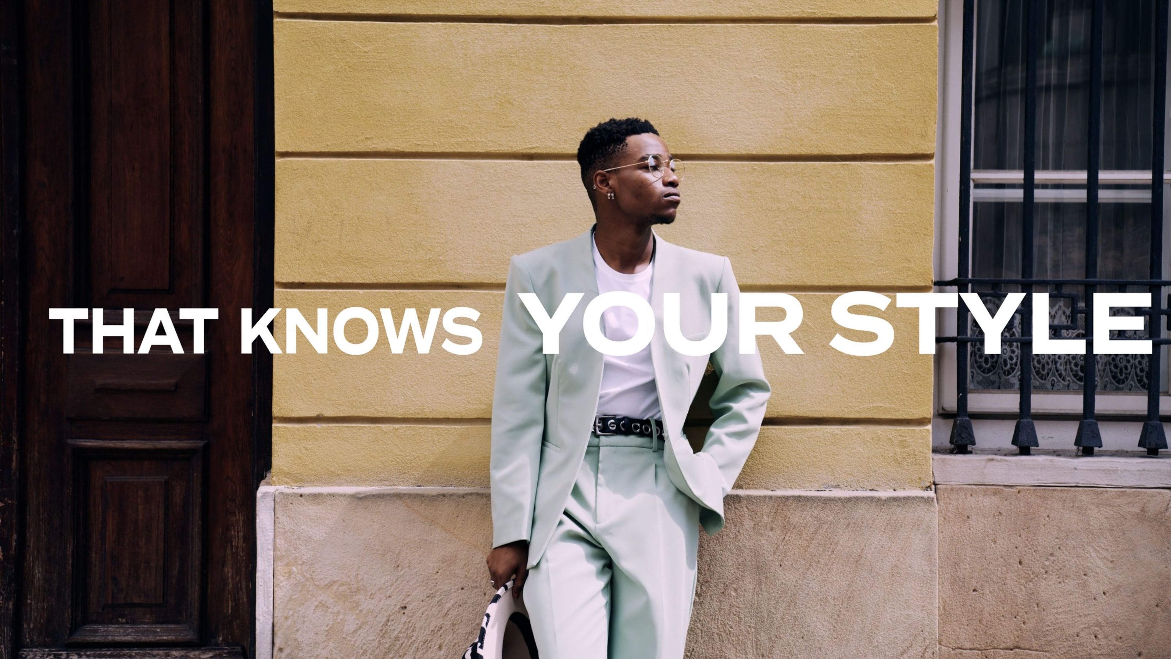 Man in a pale green suit against a yellow wall, with the text 'That knows your style'