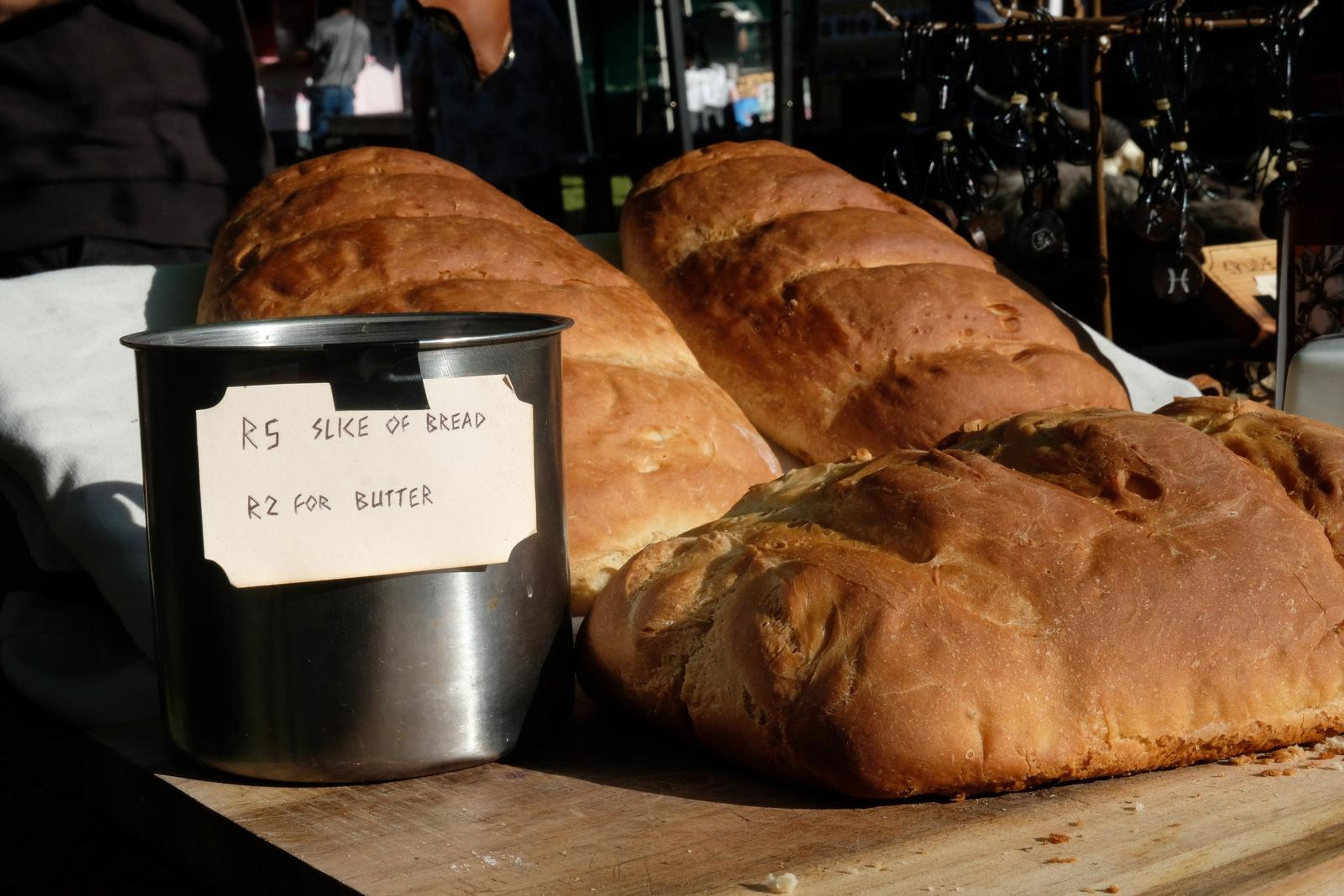 Neighbouring stall with loaves of bread and a price tin at Windsong Boho market