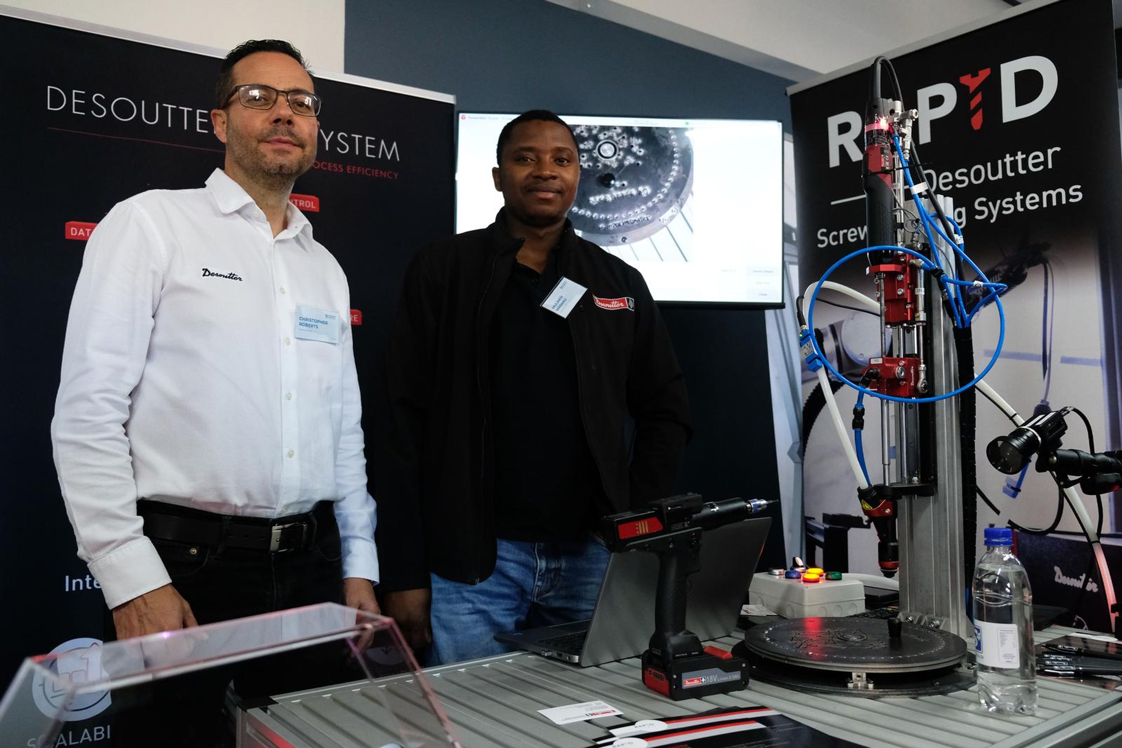 Two Desoutter team members posing at their stand