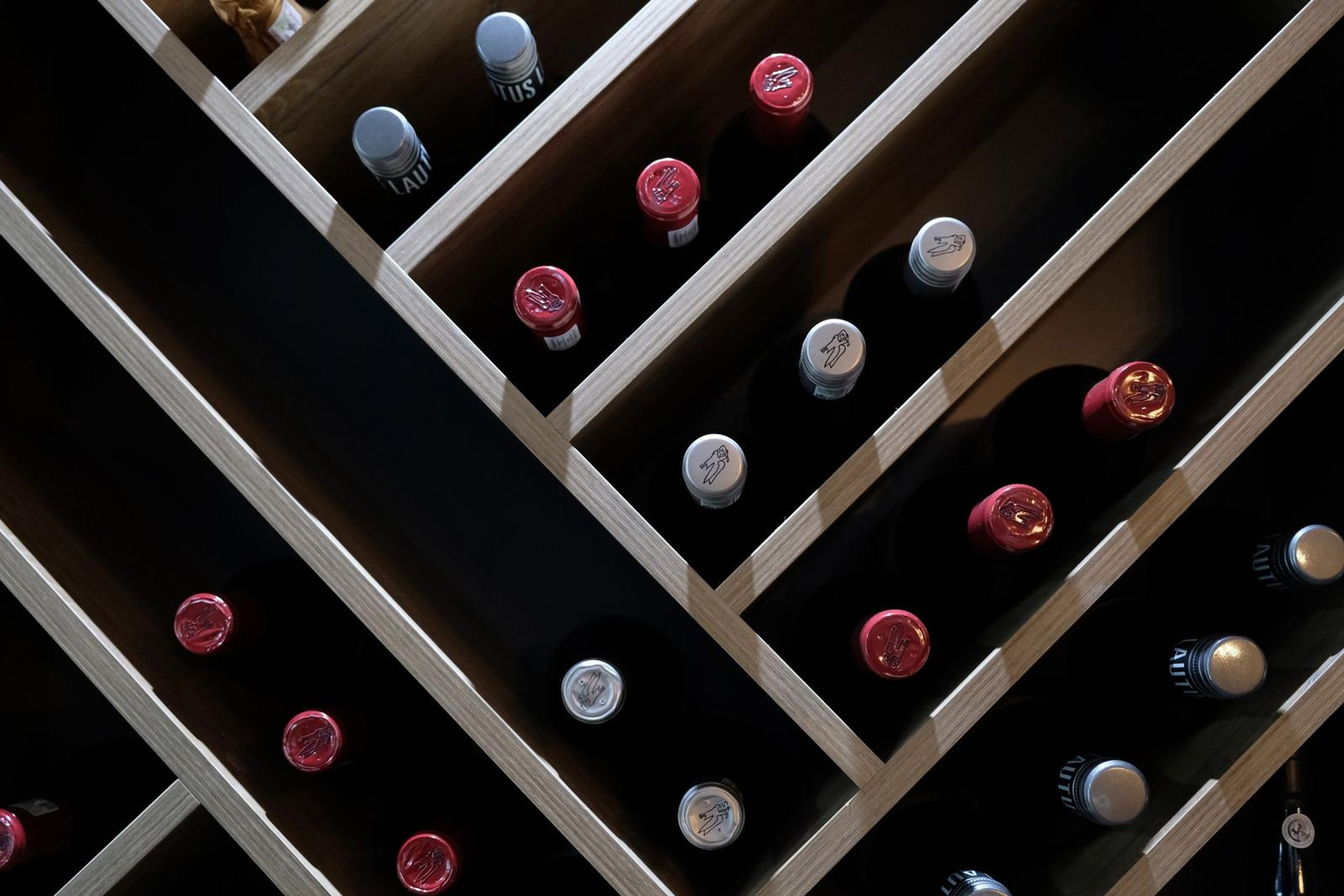 Wine rack with bottles lying in angled wooden compartments
