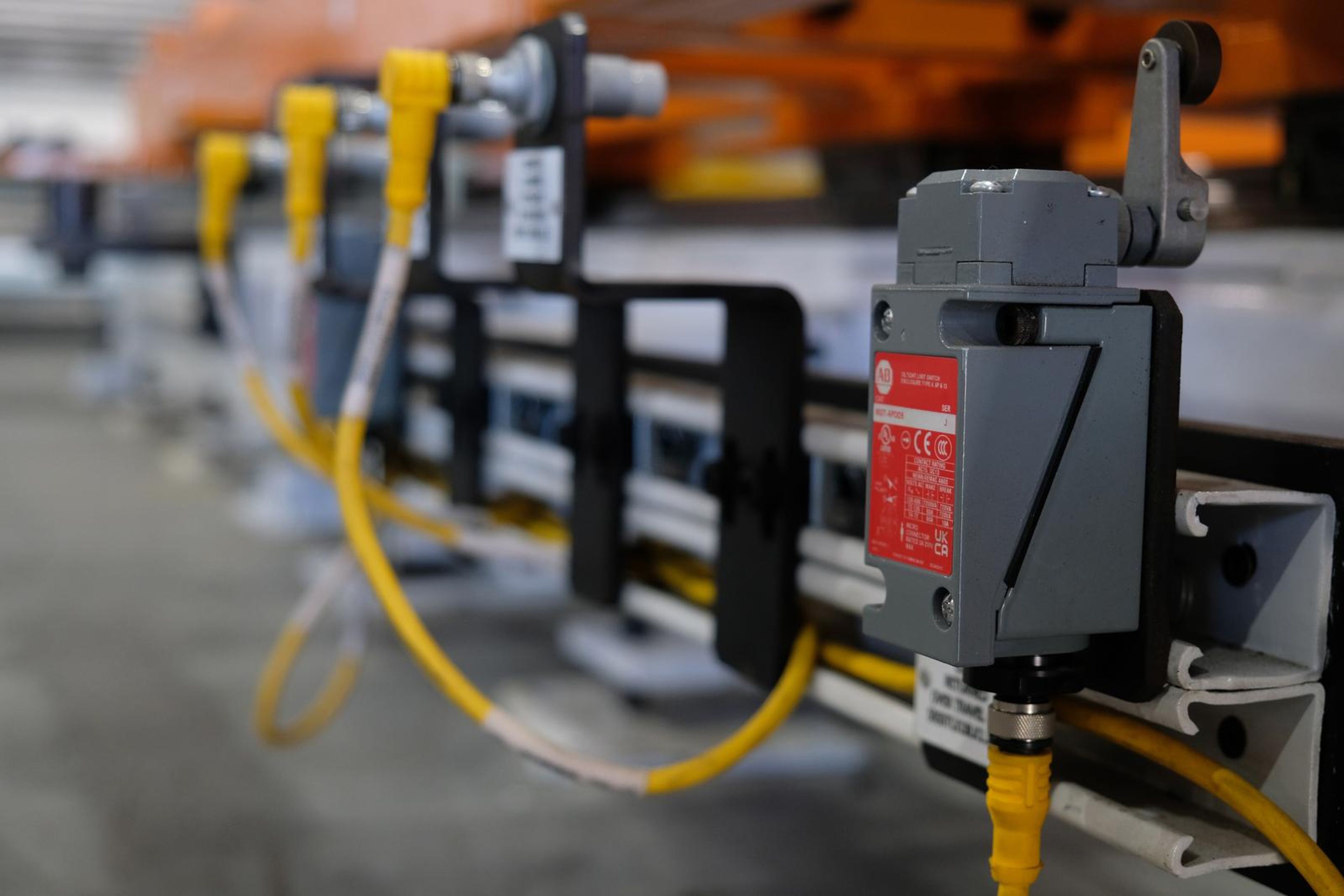 Limit switches and yellow cables mounted on a rail