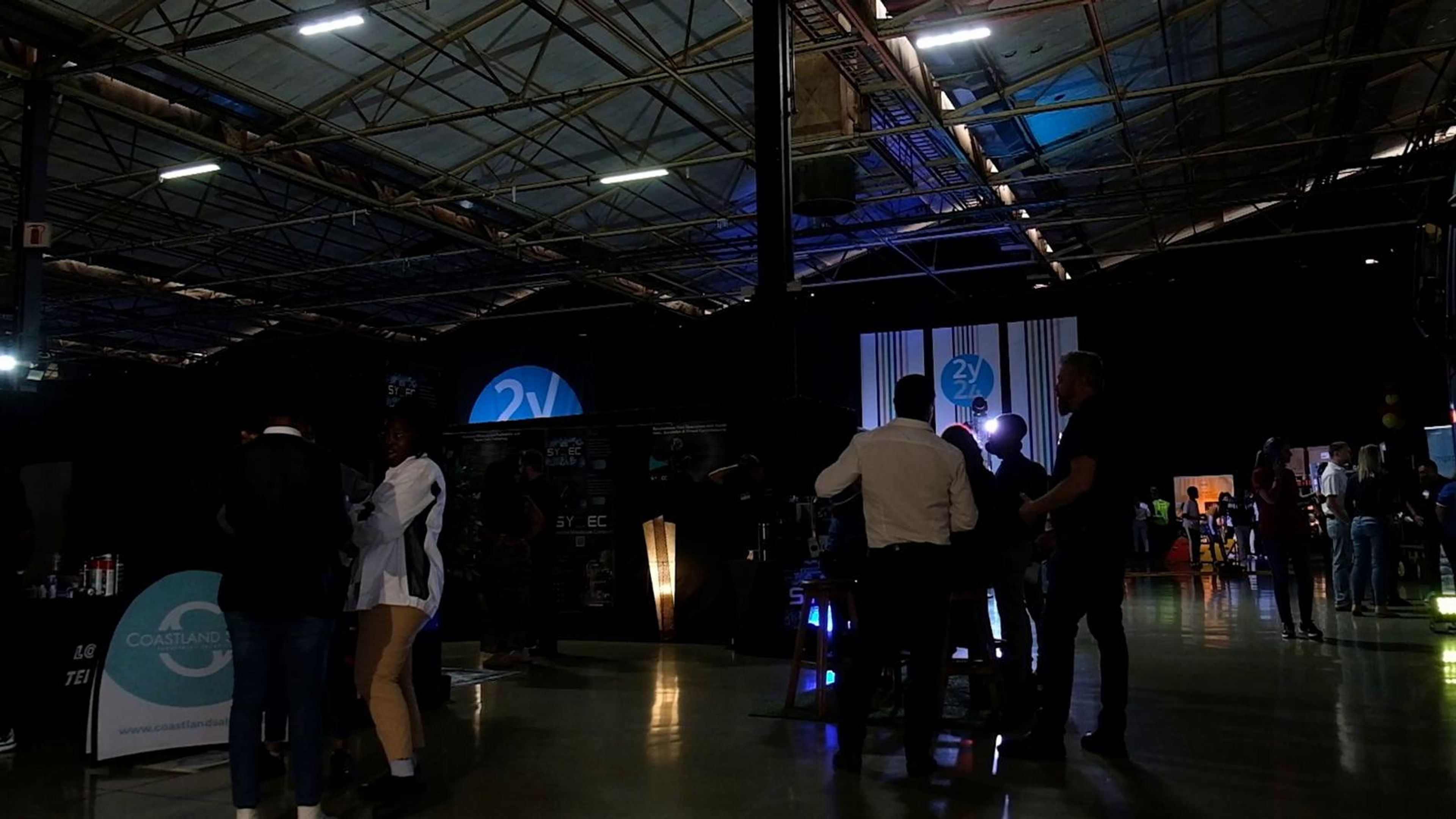 Visitors walking through the dark expo hall