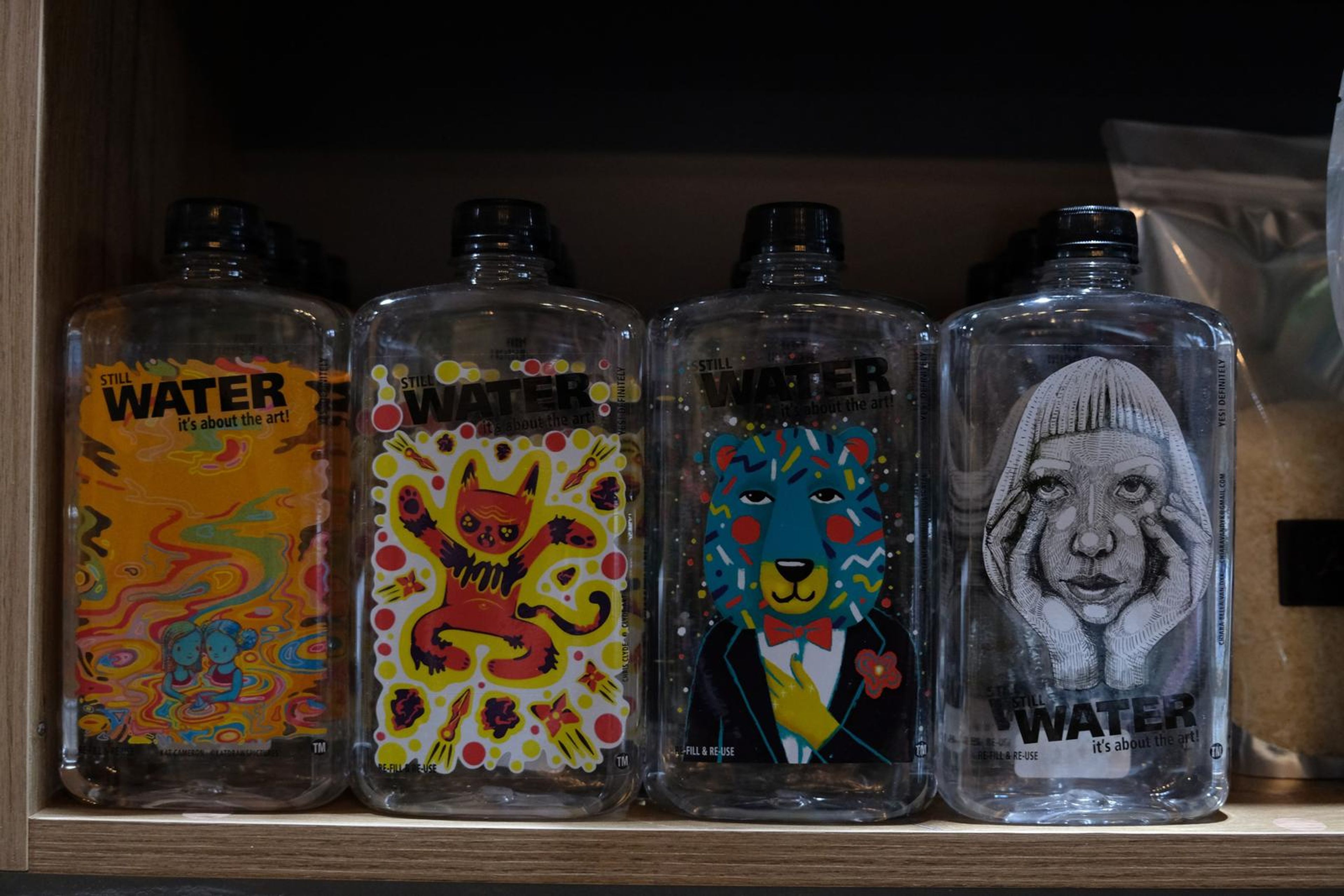 Four illustrated Water bottles lined up on a shelf