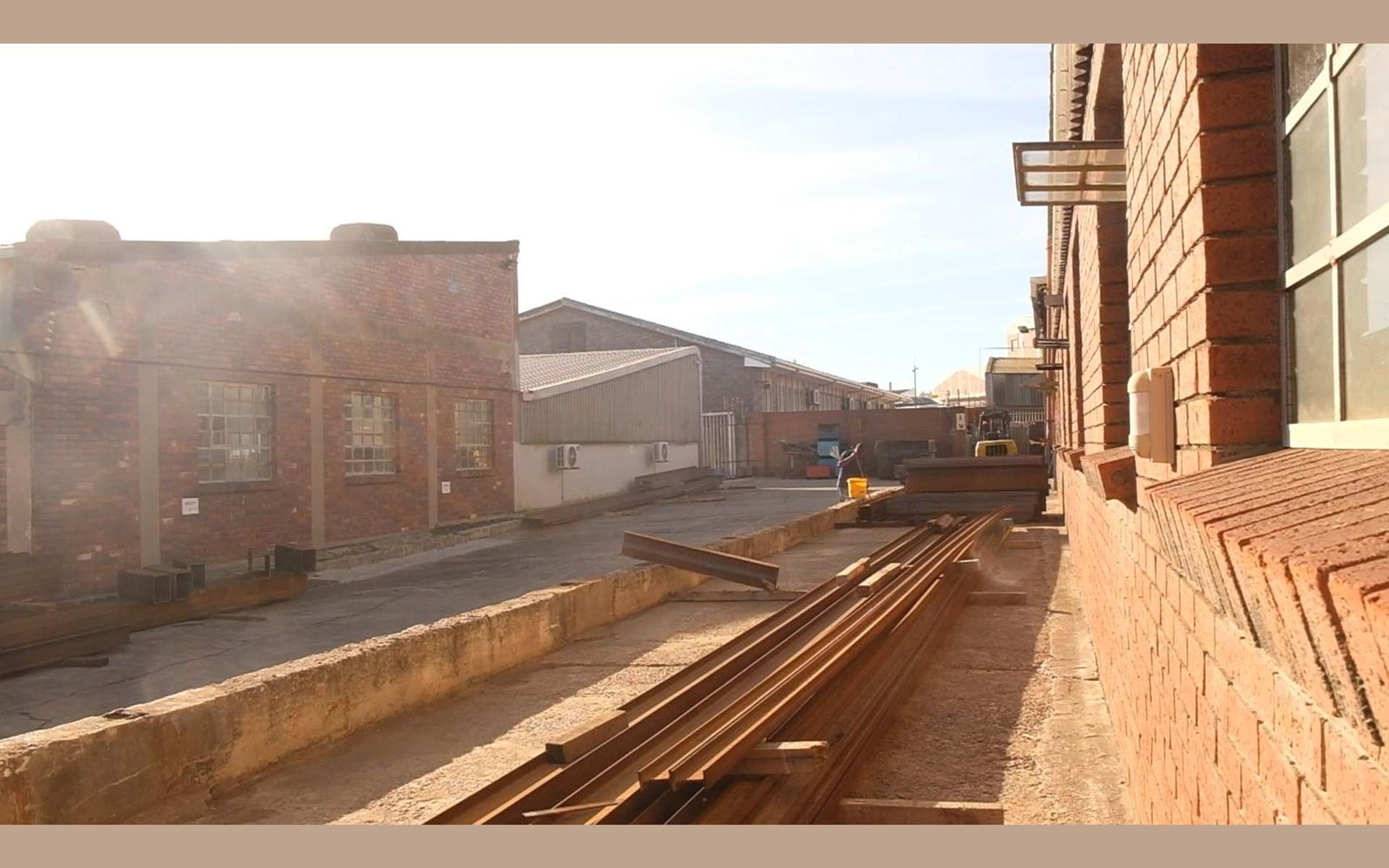 Steel rails running along the yard in late sun