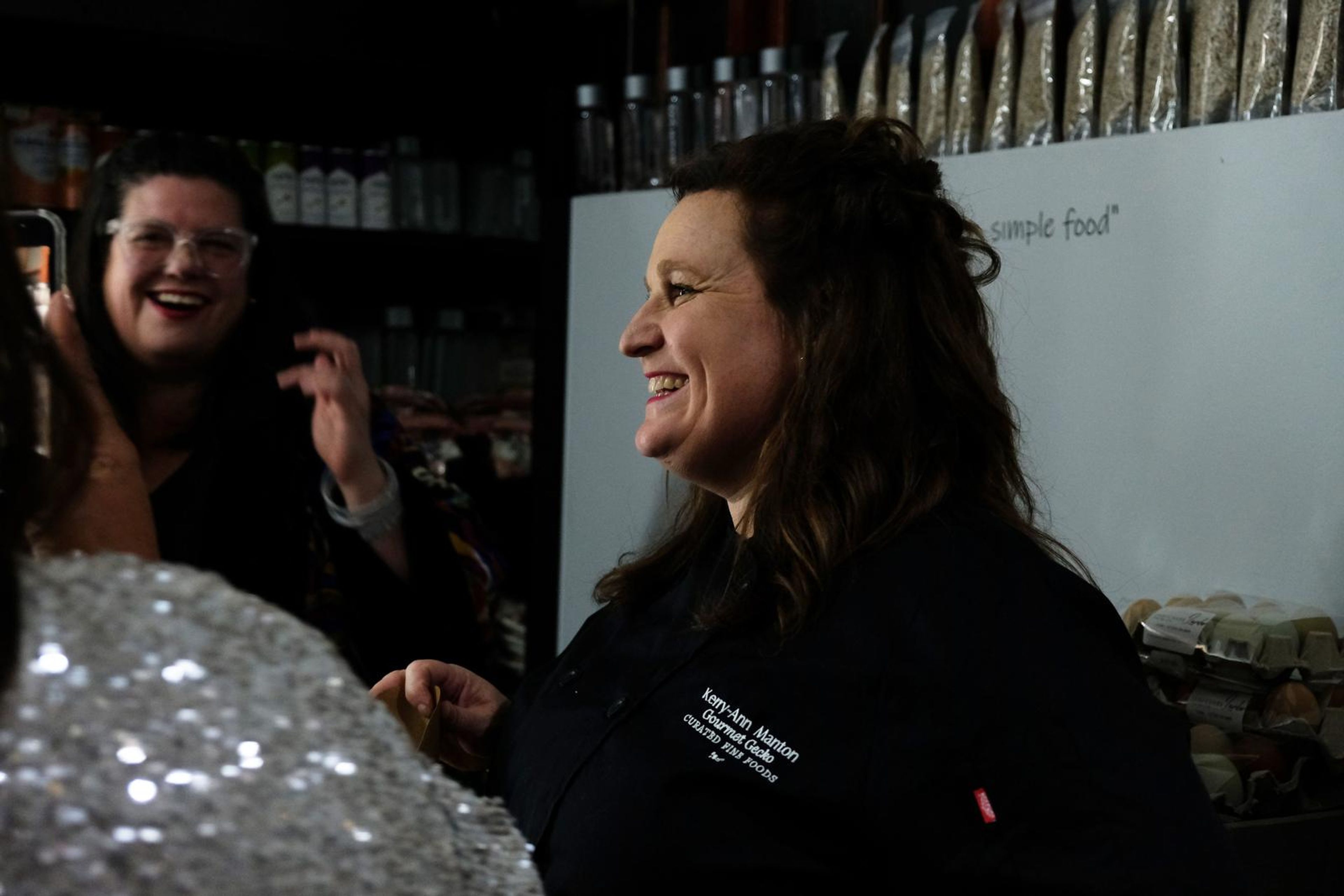 Chef laughing as guests gather around her
