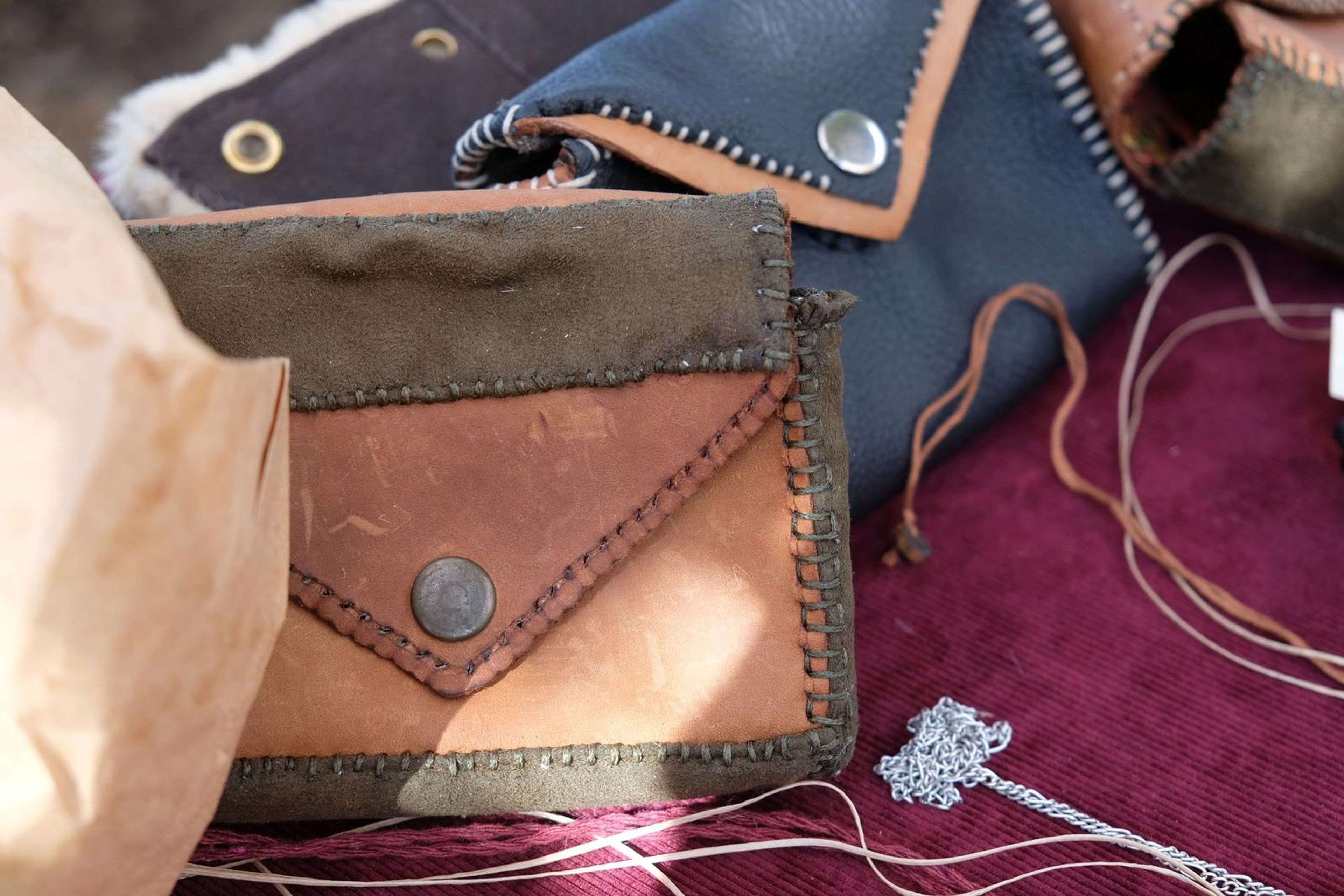 Leather envelope wallet in tan and olive with a brass stud and stitched edge