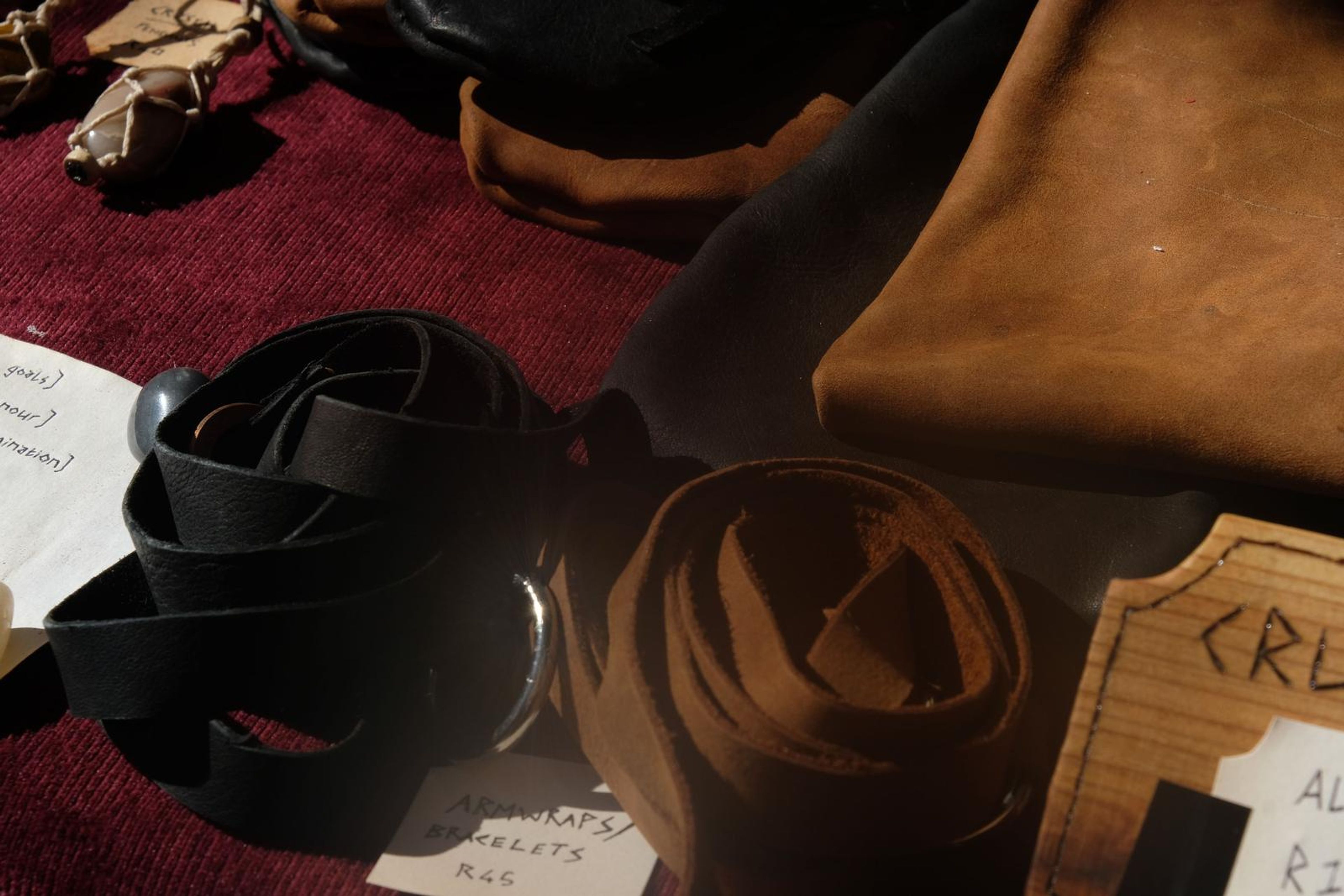 Black leather belt coiled beside a tan suede pouch