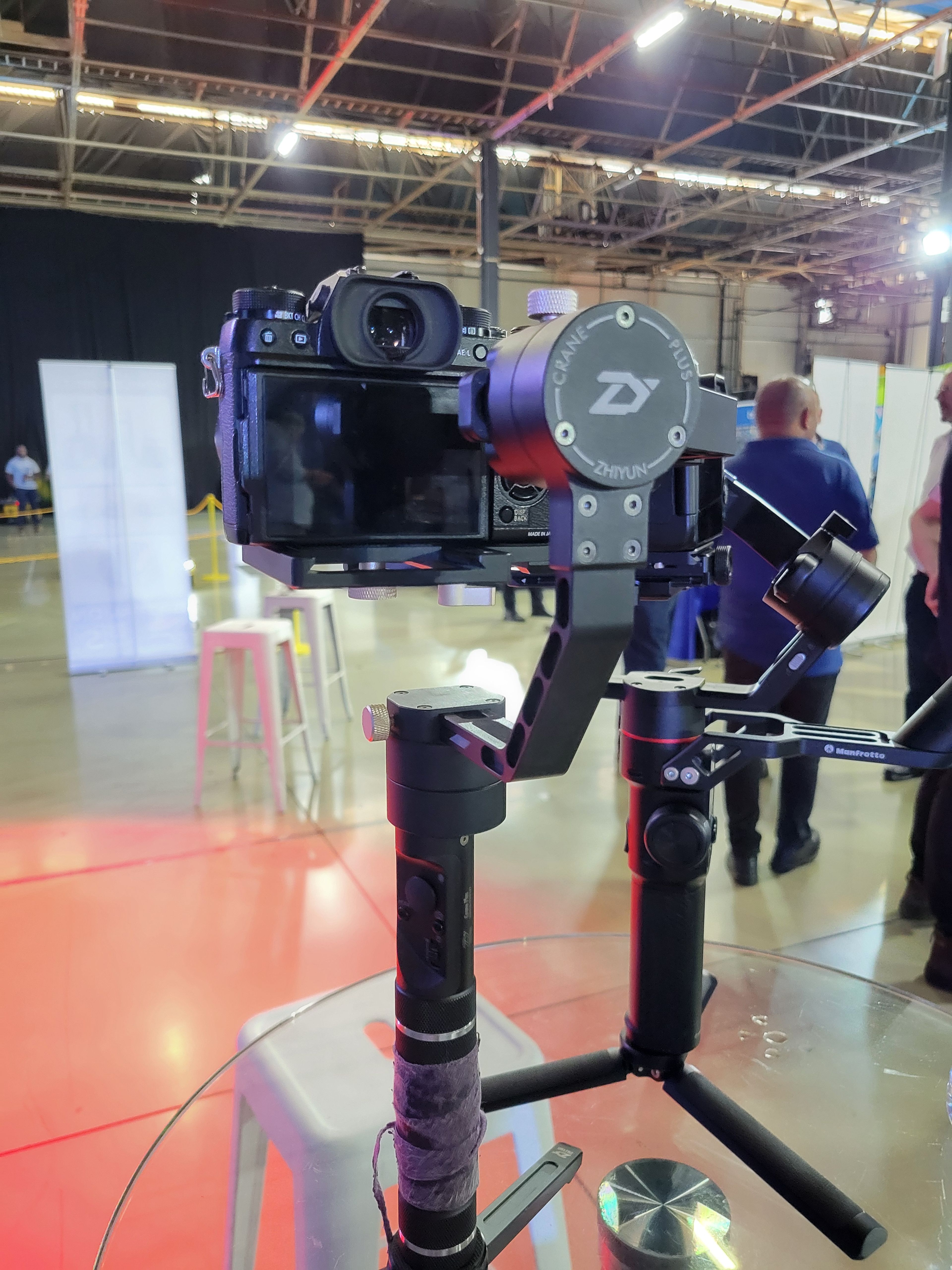 Behind the scenes at the expo, a camera on a gimbal stand in the exhibition hall