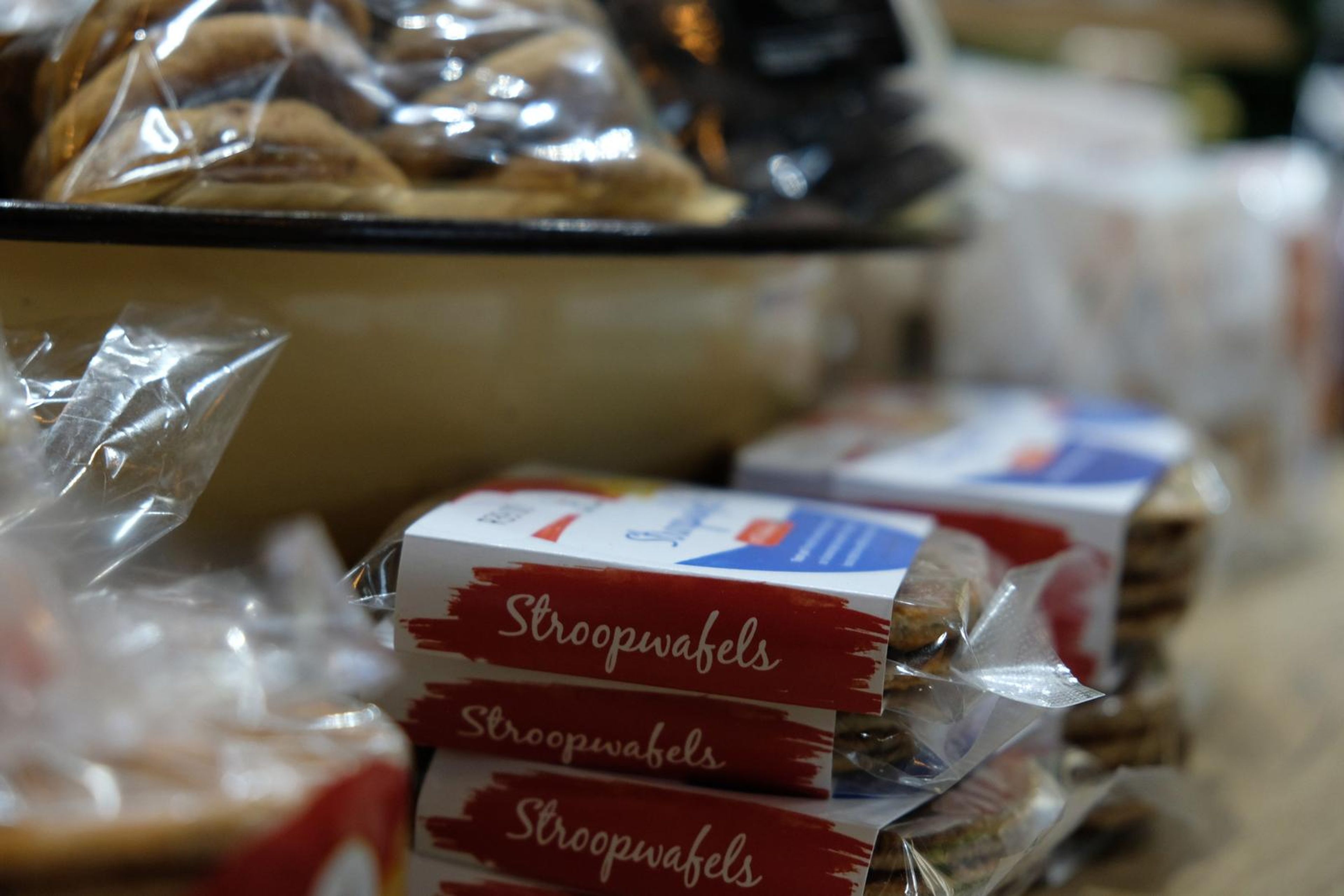 Packs of stroopwafels stacked on a wooden counter
