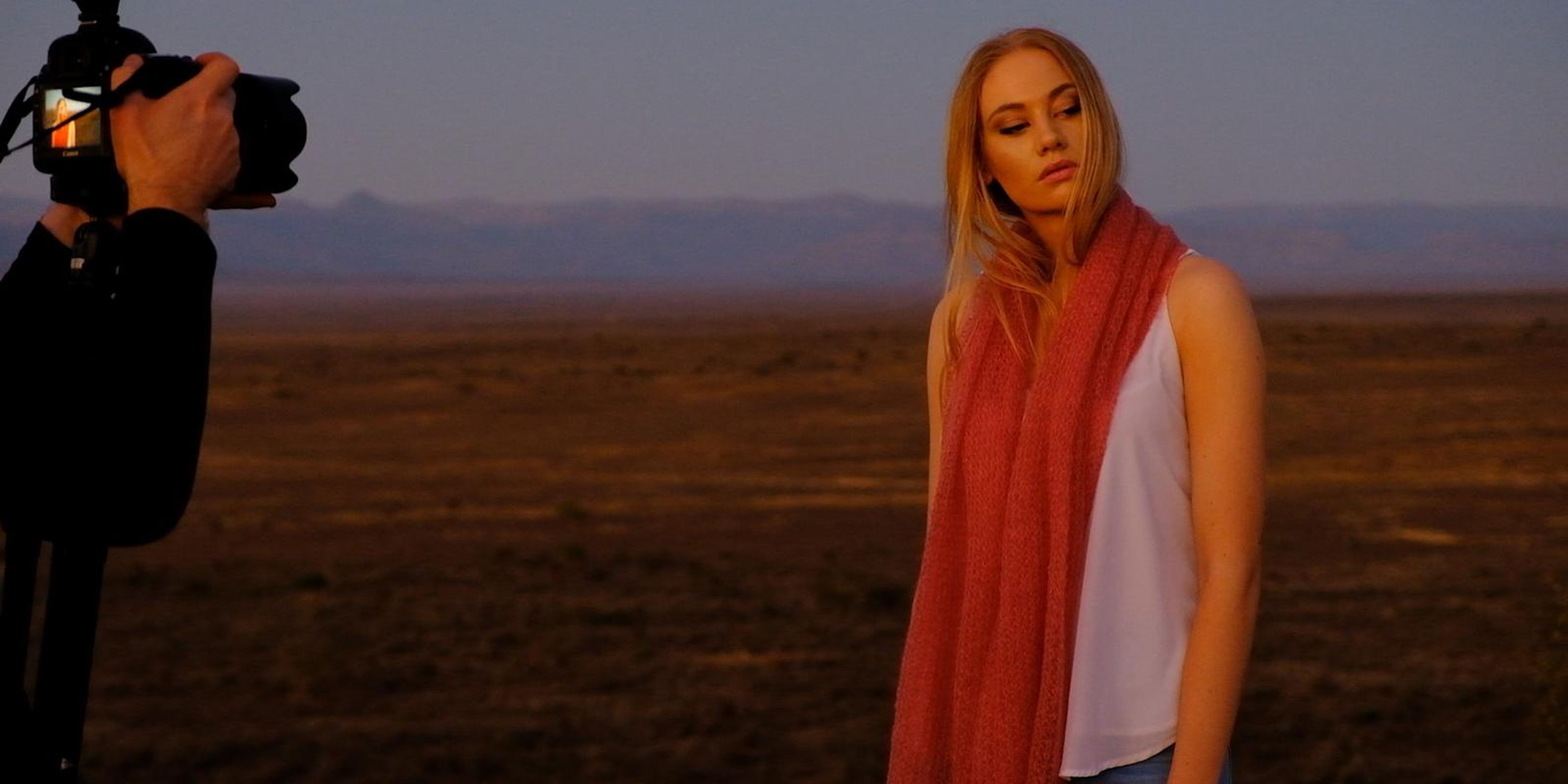 Model in a long orange-red mohair scarf in the last light