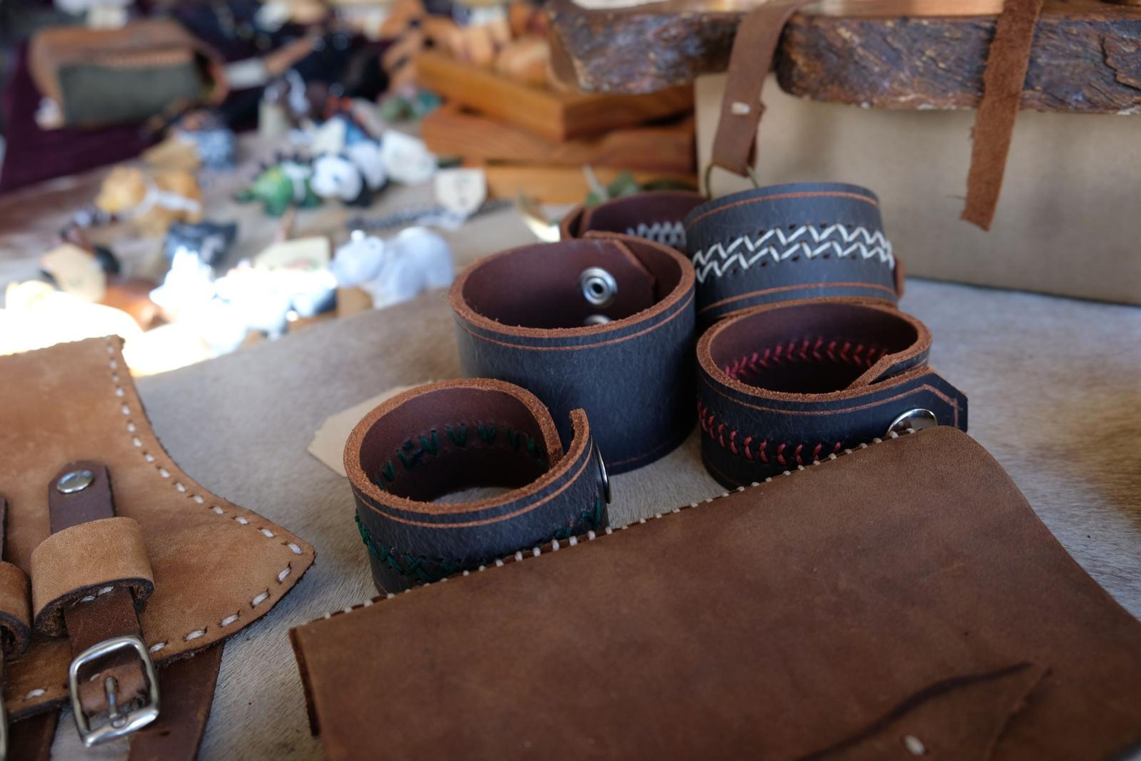Black leather cuffs and tan leather wrist guards laid on a hide