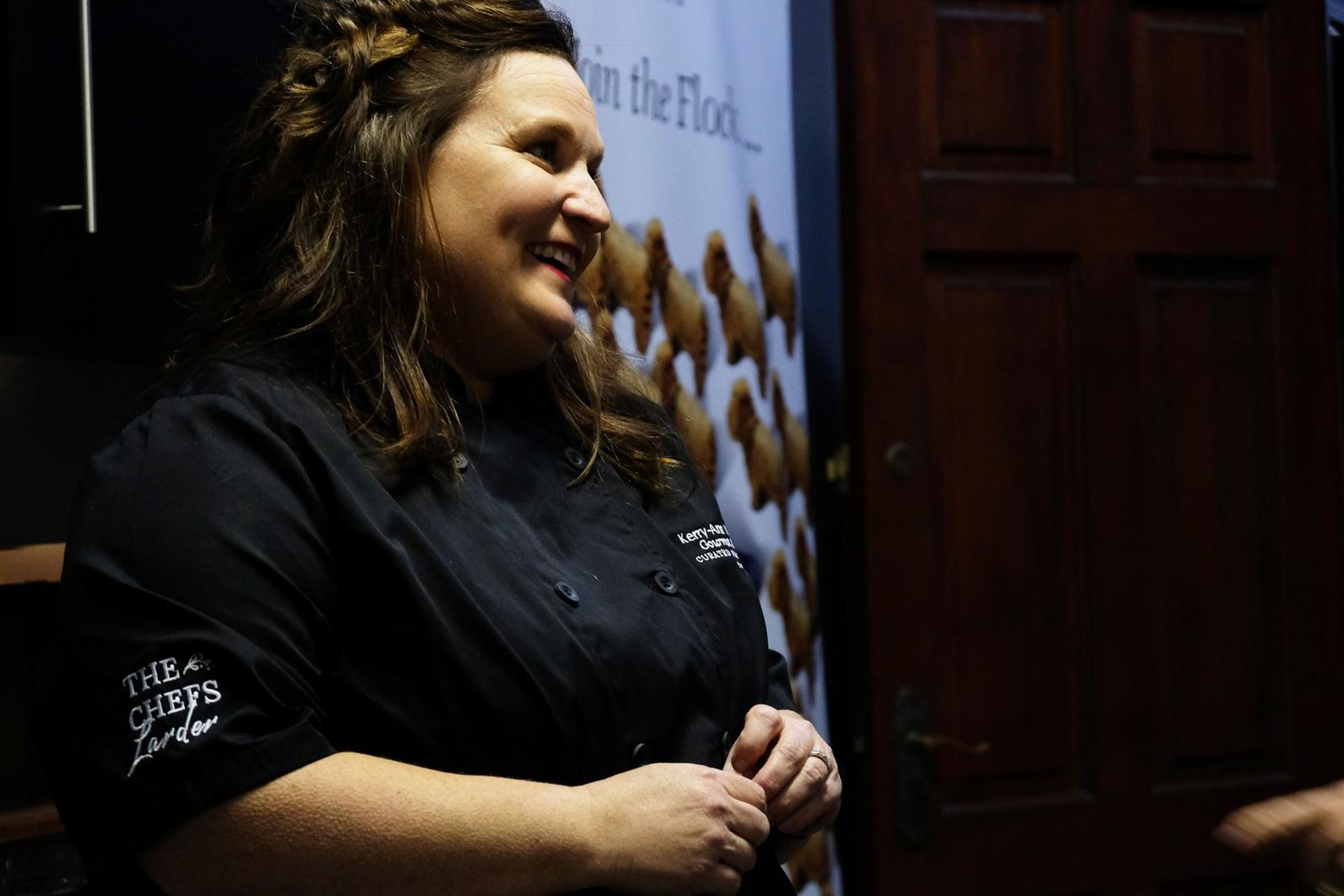 Smiling chef in a black Chef's Larder jacket at the opening