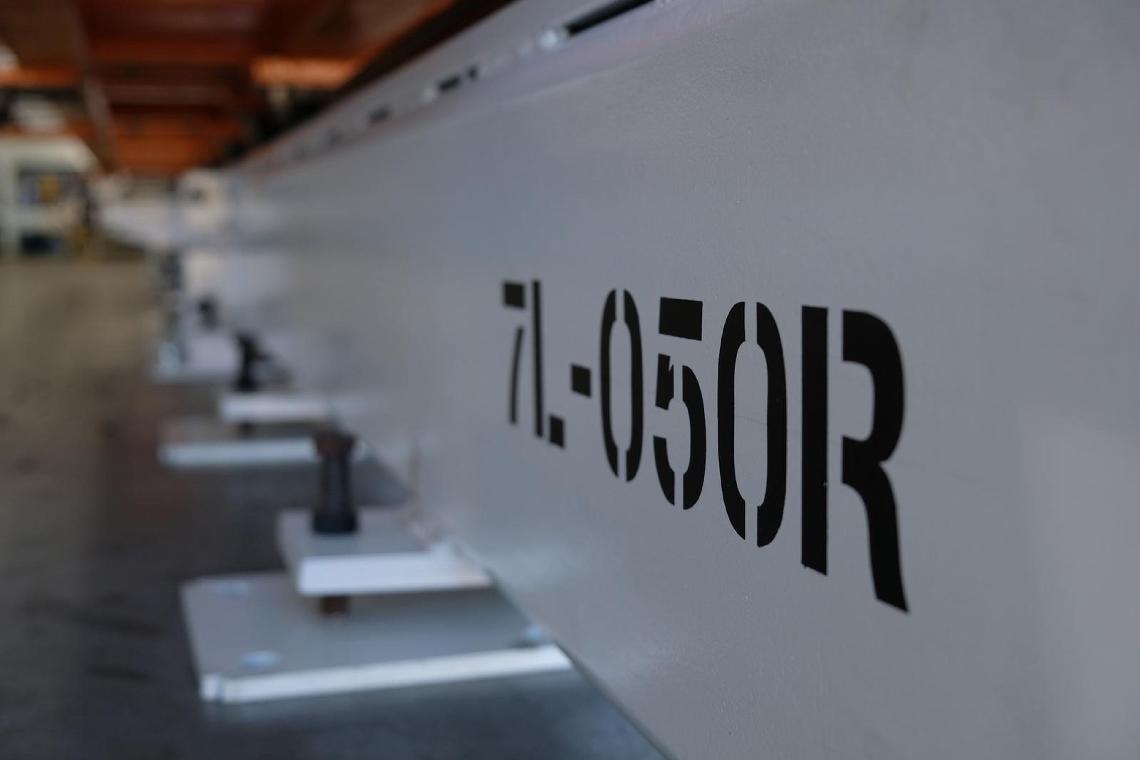 White steel beam stencilled 7L-050R receding along the plant floor