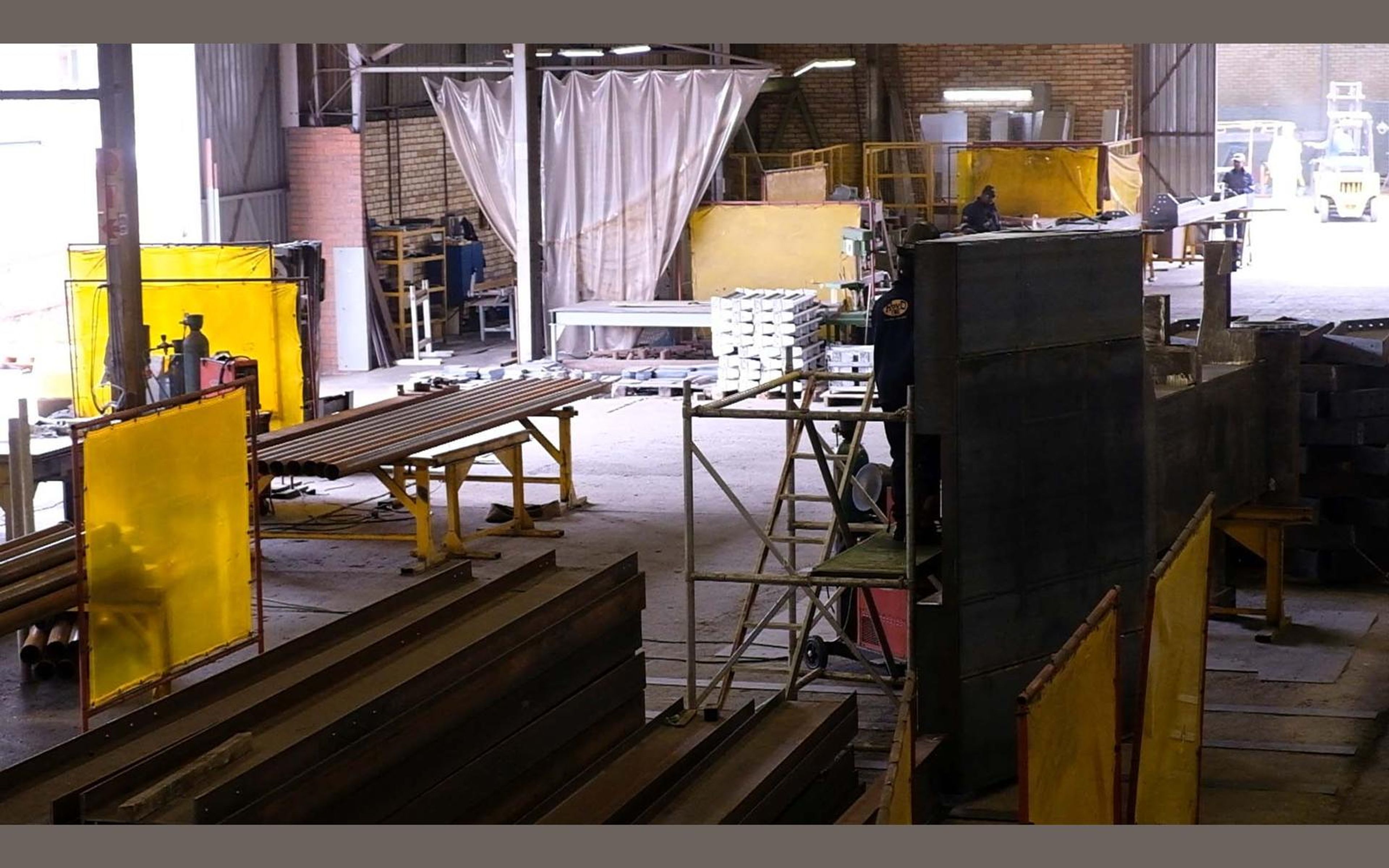 Wide view of the fabrication sector with steel frames on the floor