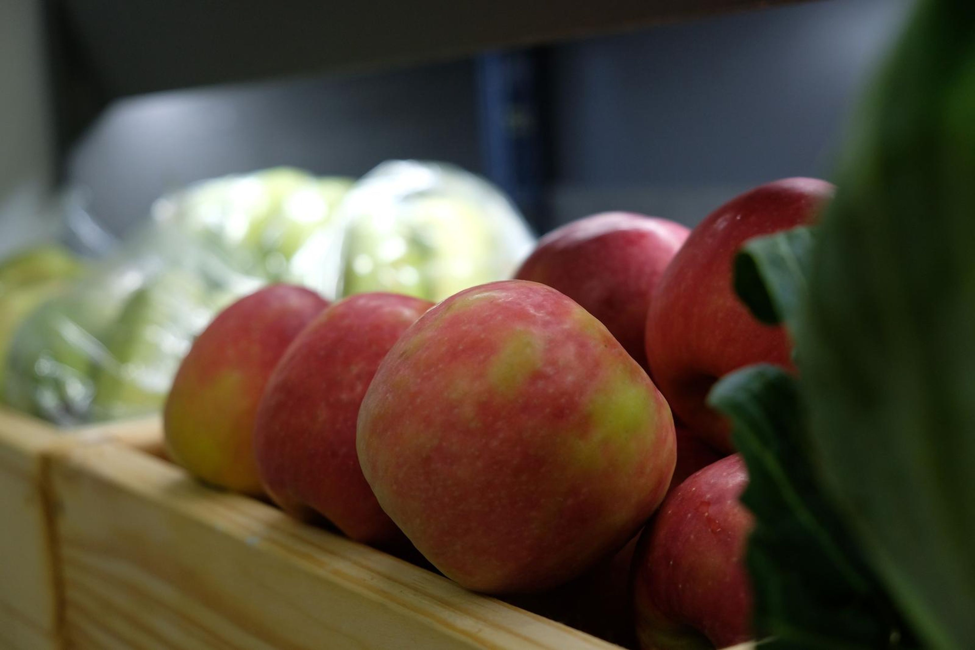 Red apples and cabbage in a wooden crate