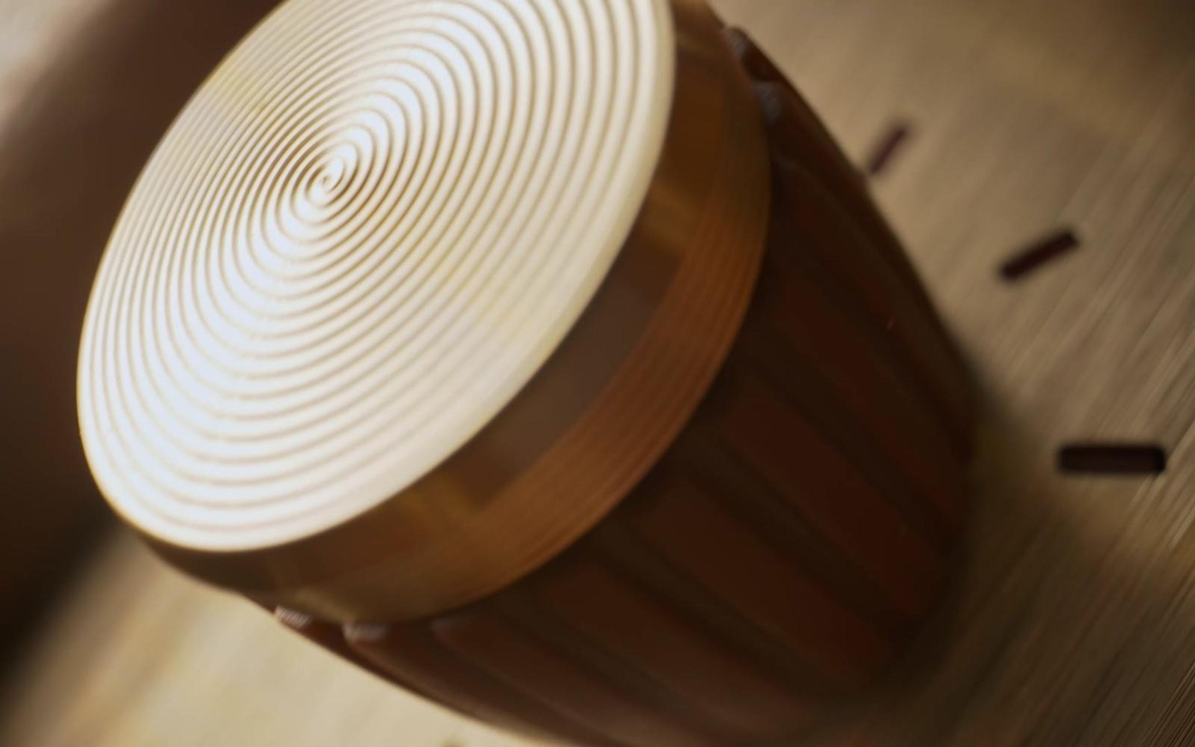 Gold and wood amp knob angled against pale dial markings in soft light