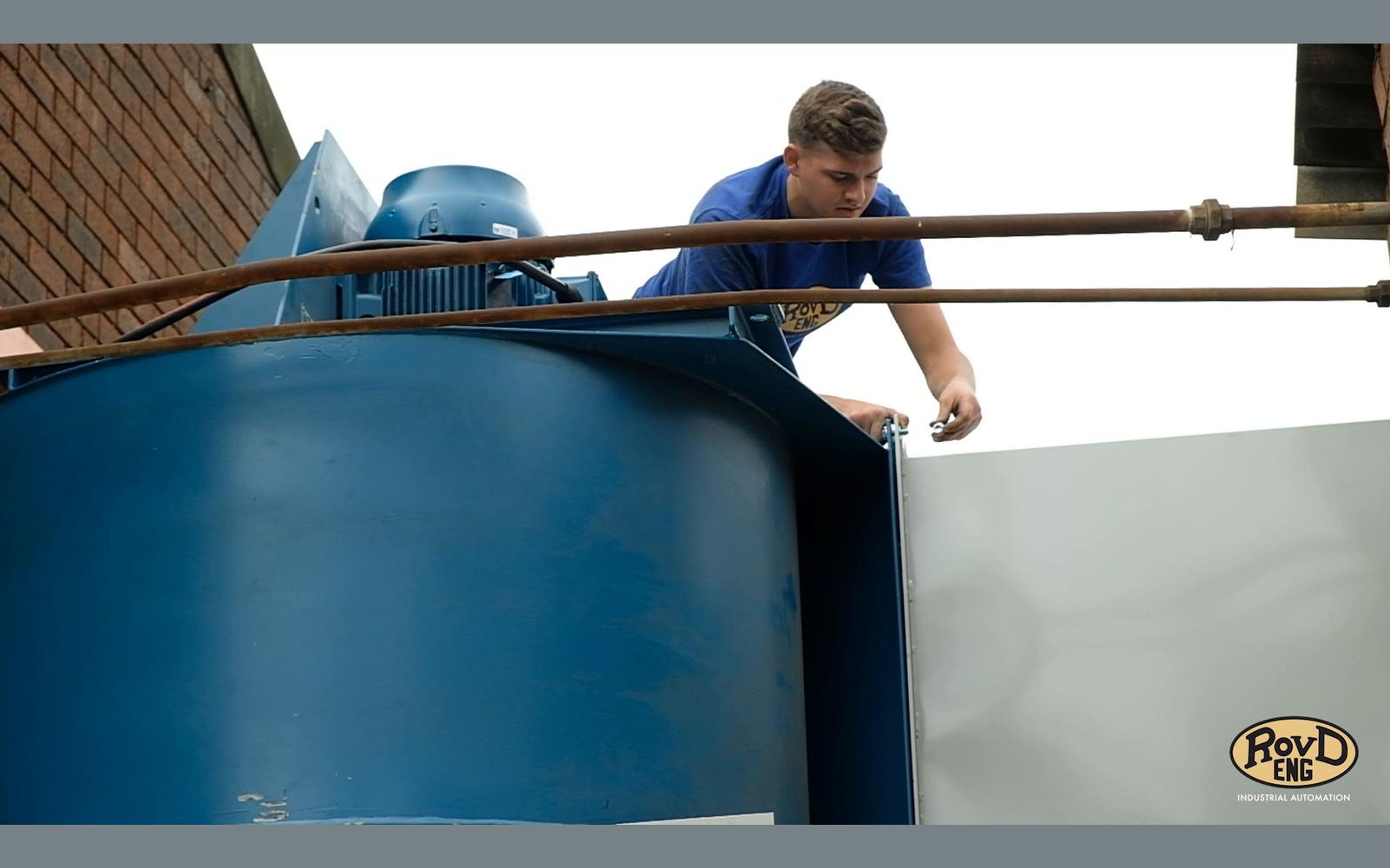 Worker on top of a blue tank