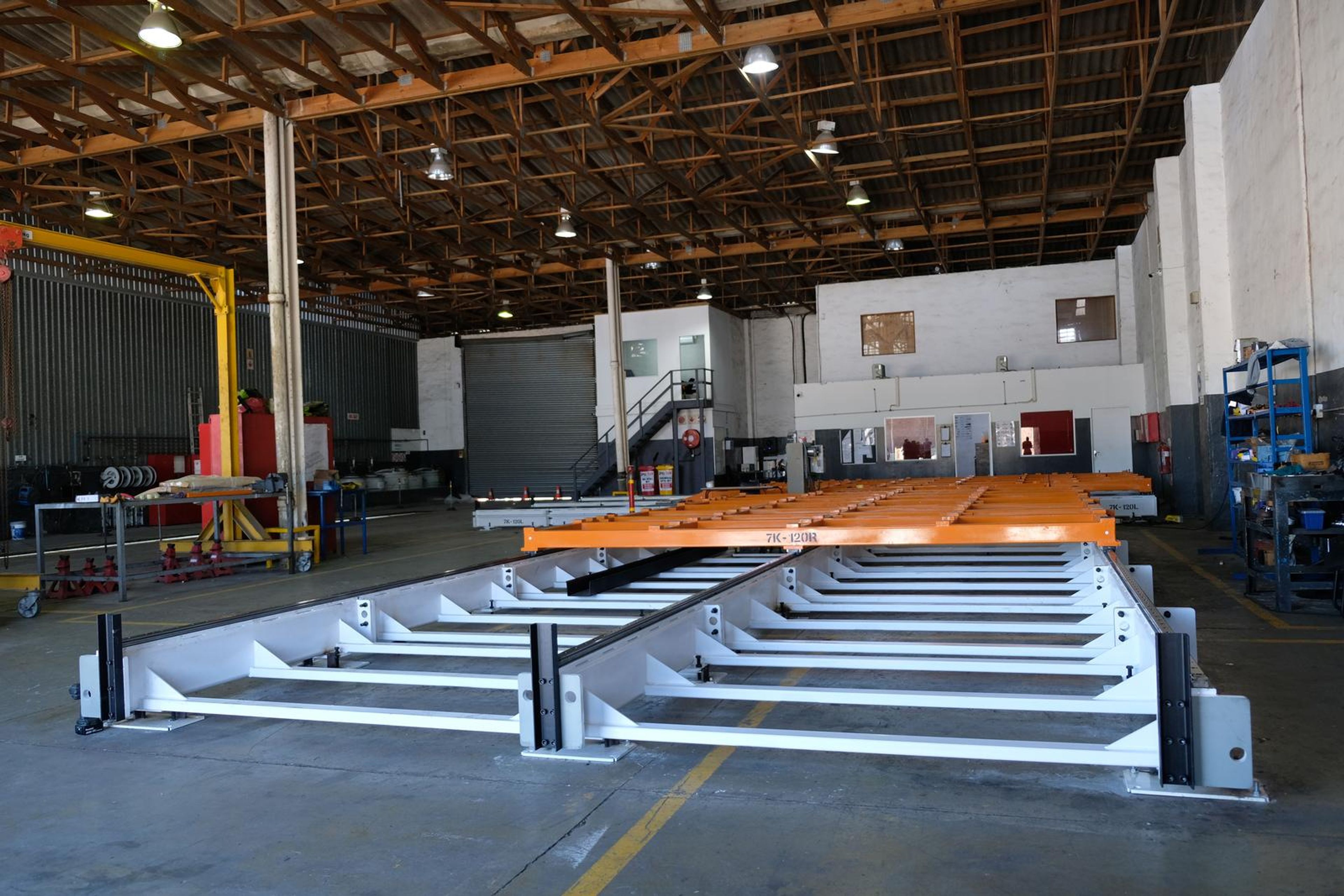 White steel base frame stretching down the plant bay beneath an orange beam