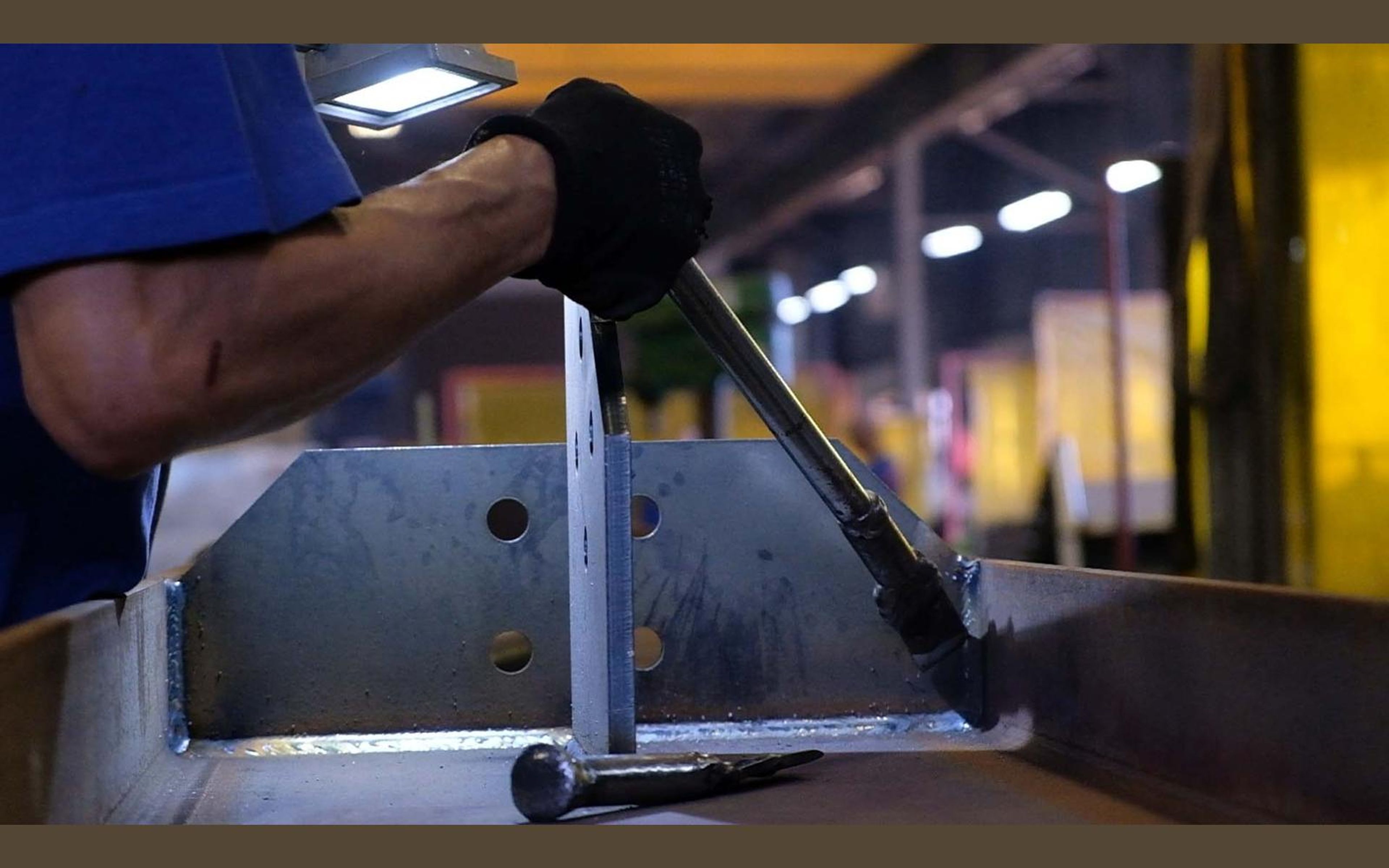 Hands working on a steel part in the fabrication sector