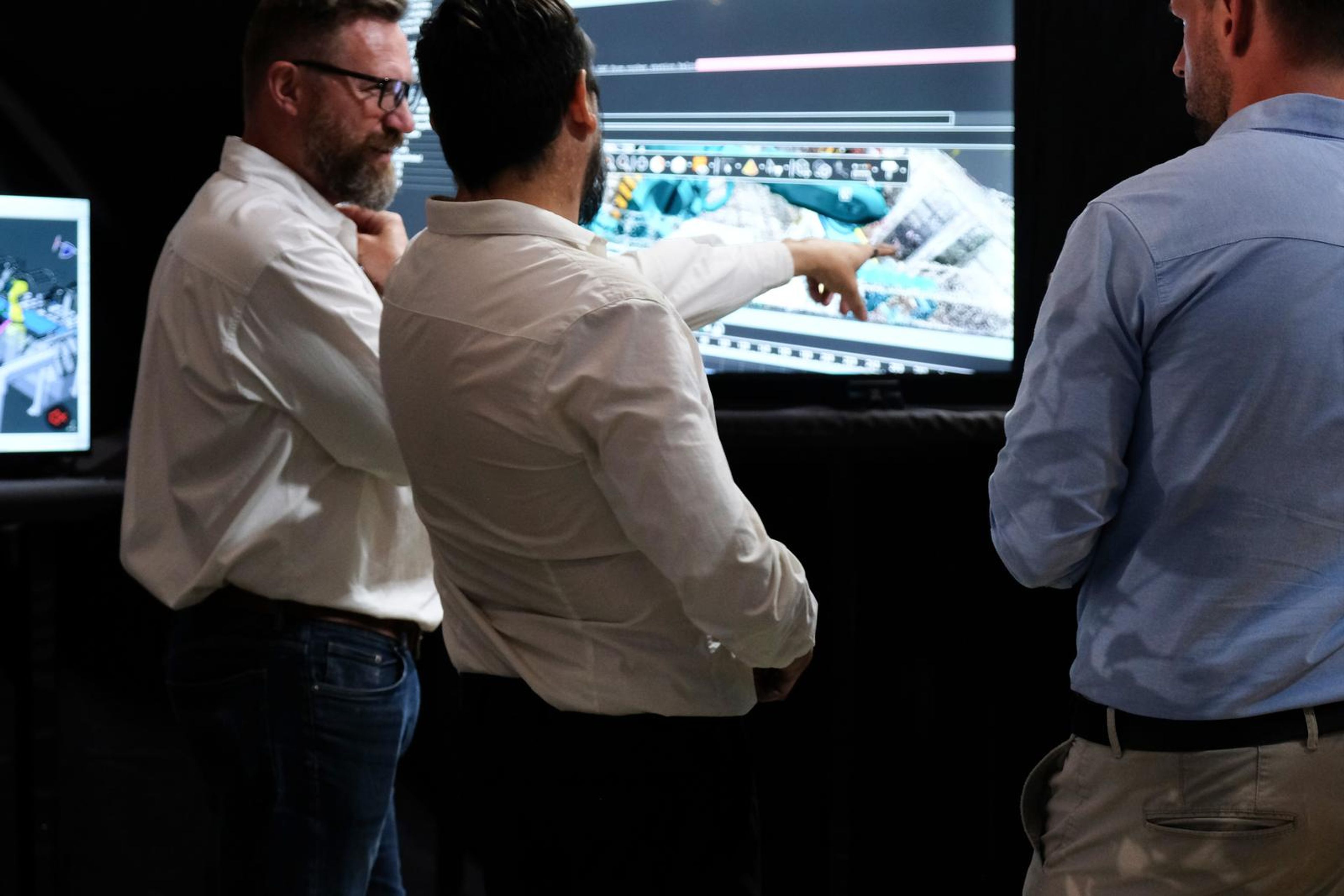 Symec's team explaining an automation simulation on a large screen to visitors