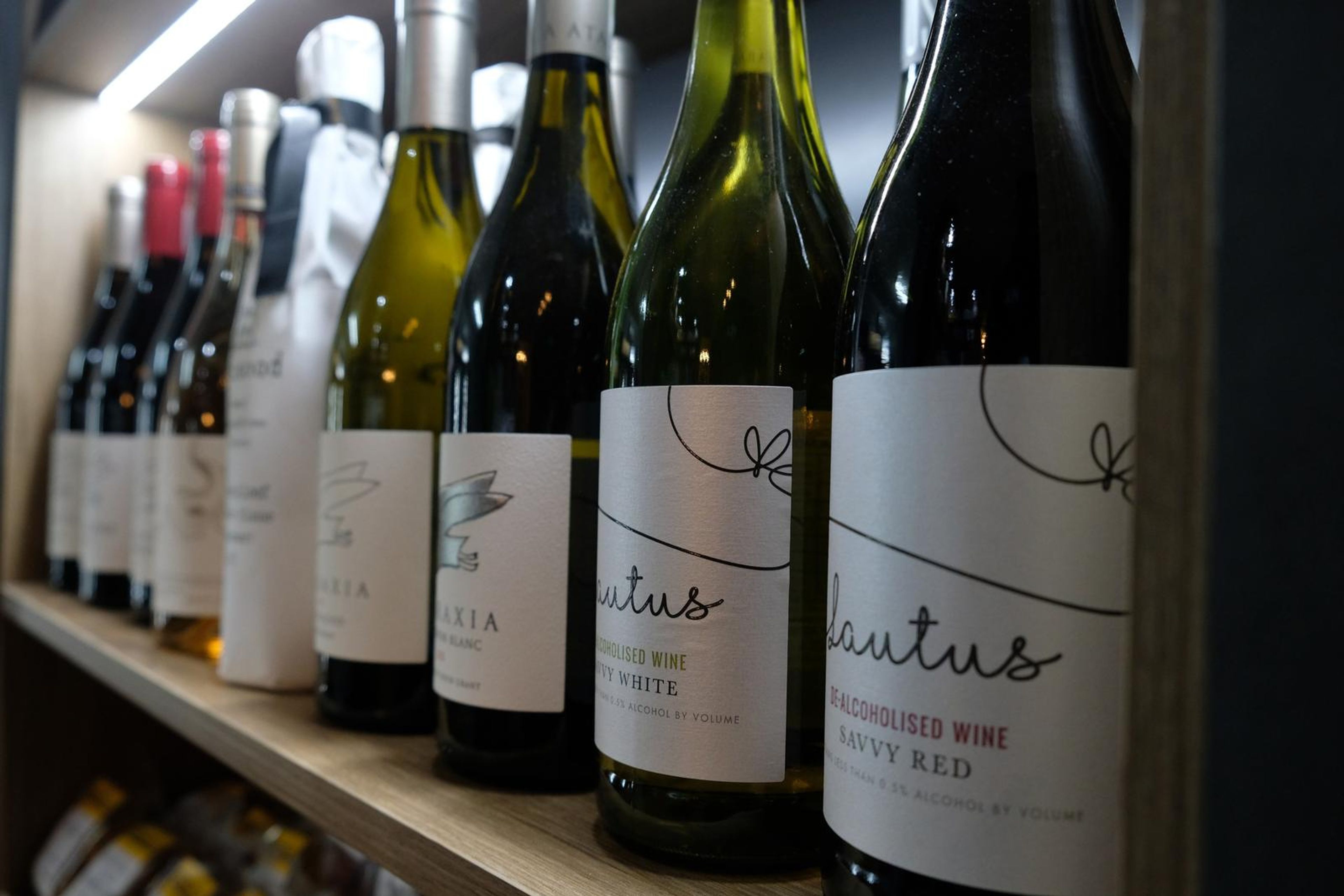 Bottles of wine lined up on a shelf with the labels showing