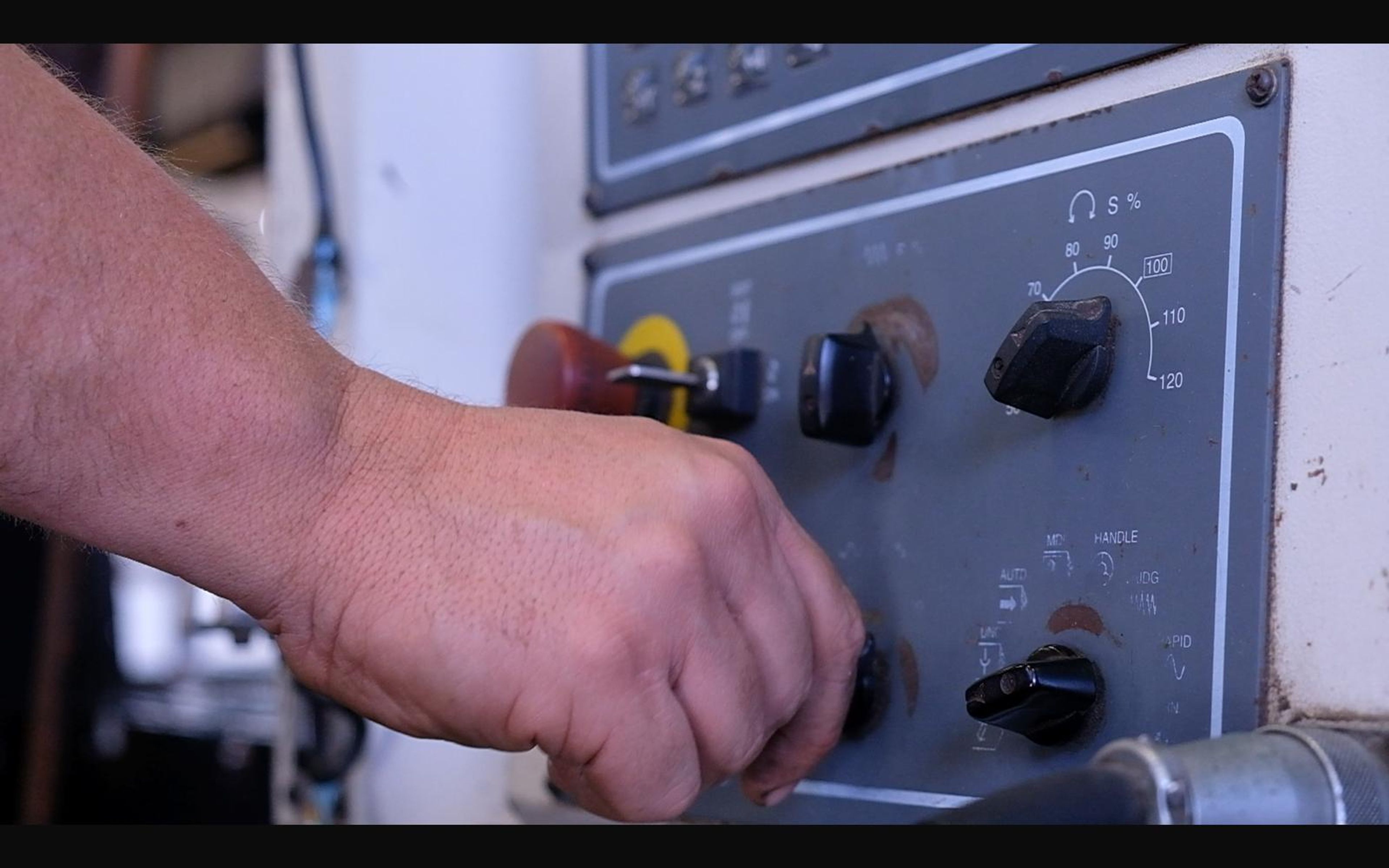 Hand on a machine control panel
