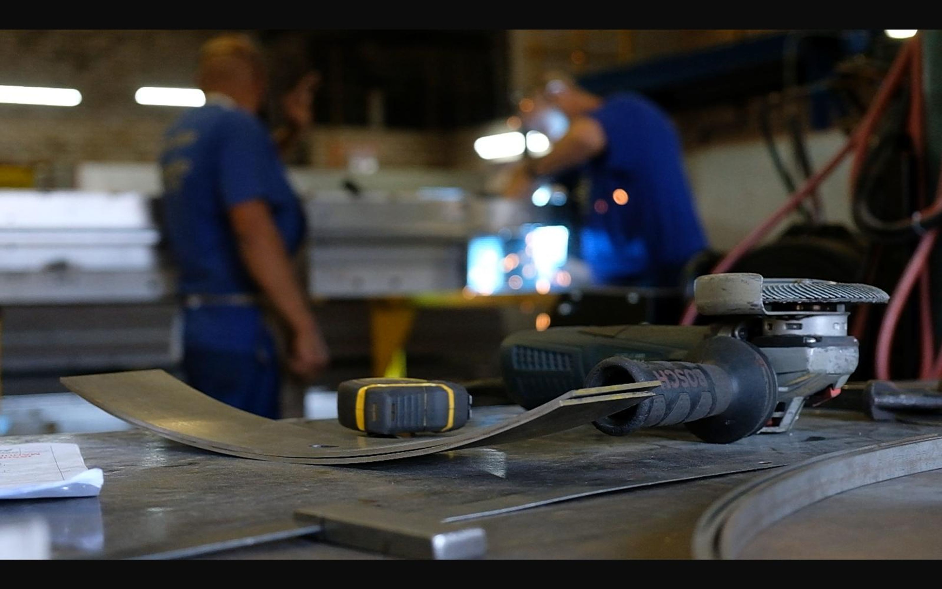 Fabricator at a bench with sheet steel