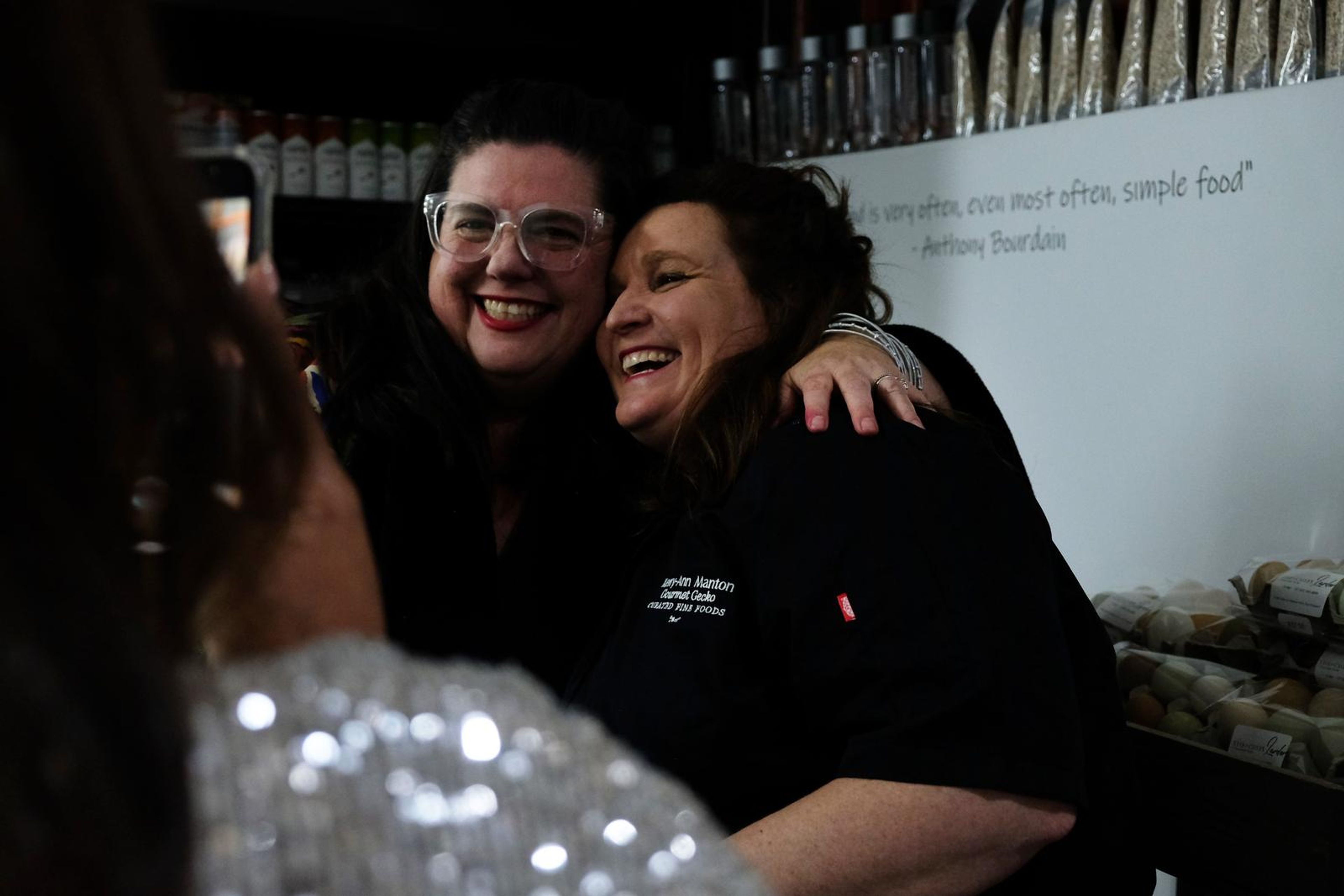 Two guests sharing a hug at the opening