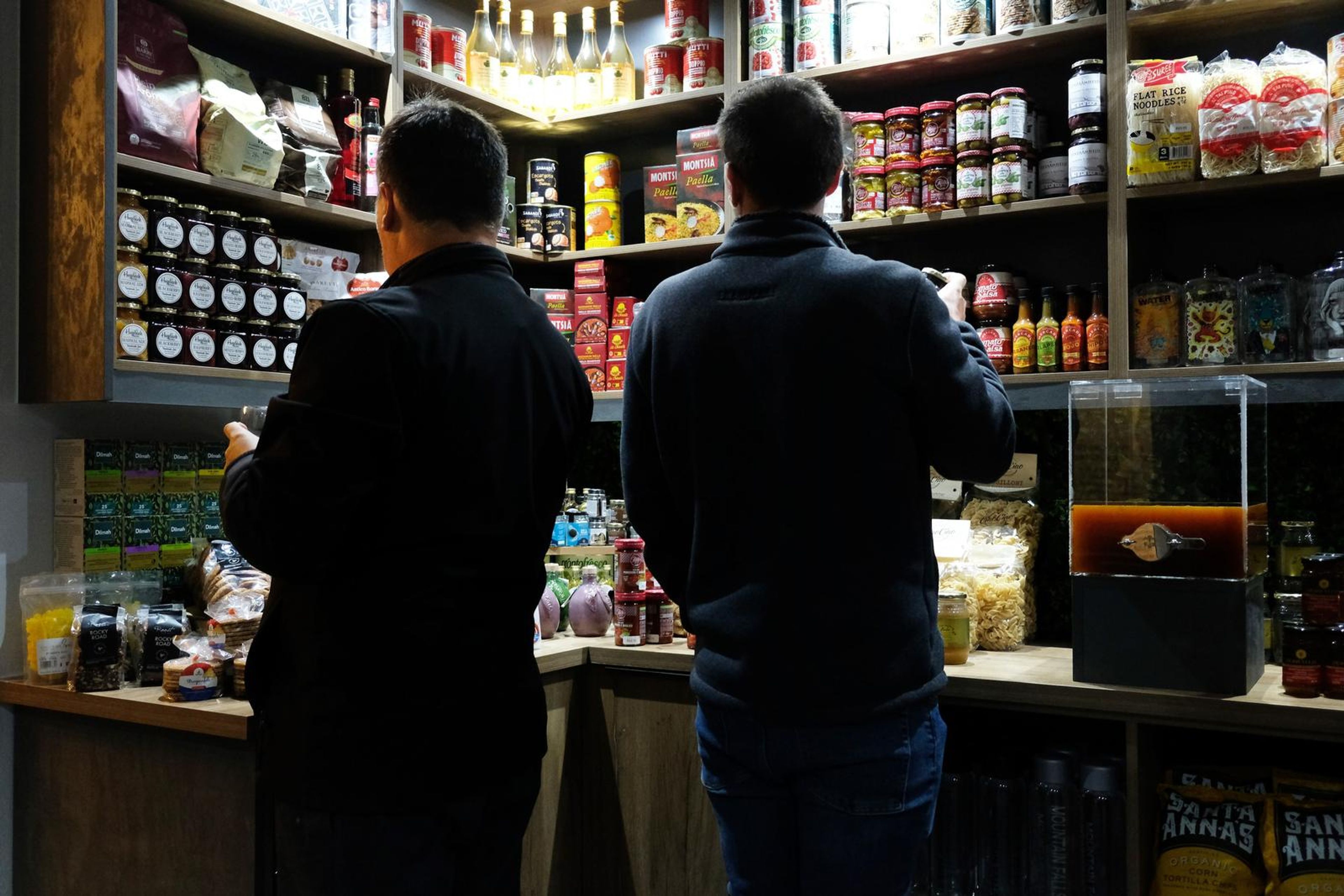 Two guests studying the pantry shelves from behind