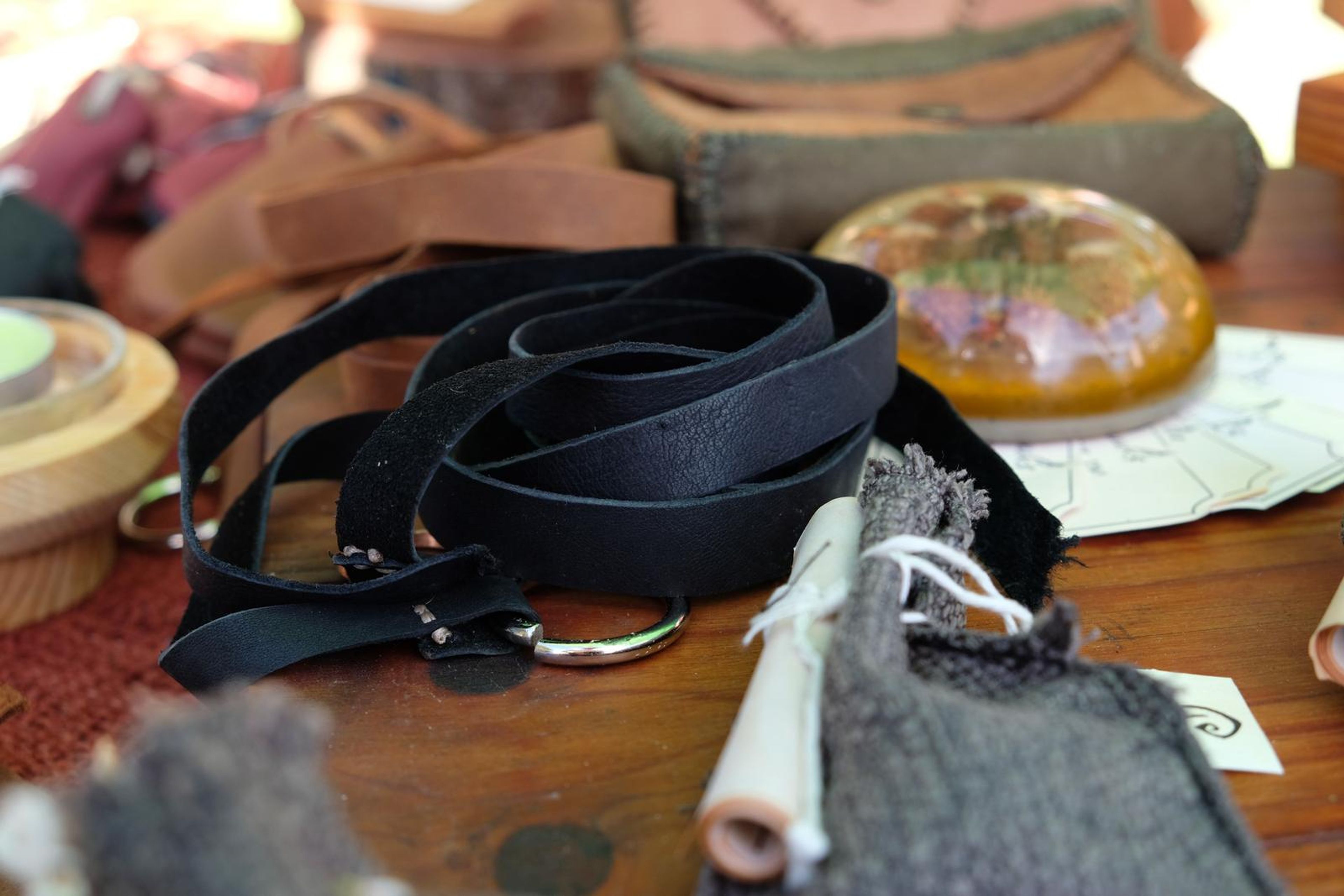 Coiled black leather strap beside a resin dome on the Juuks table