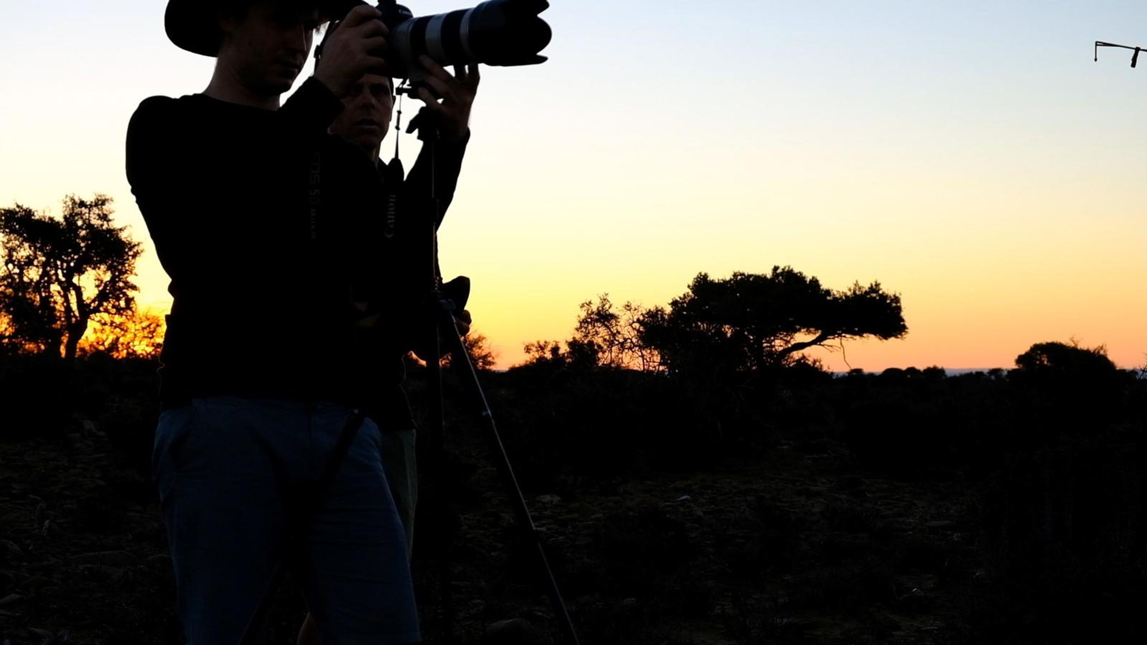 Photographer silhouetted against the sunset with a long lens