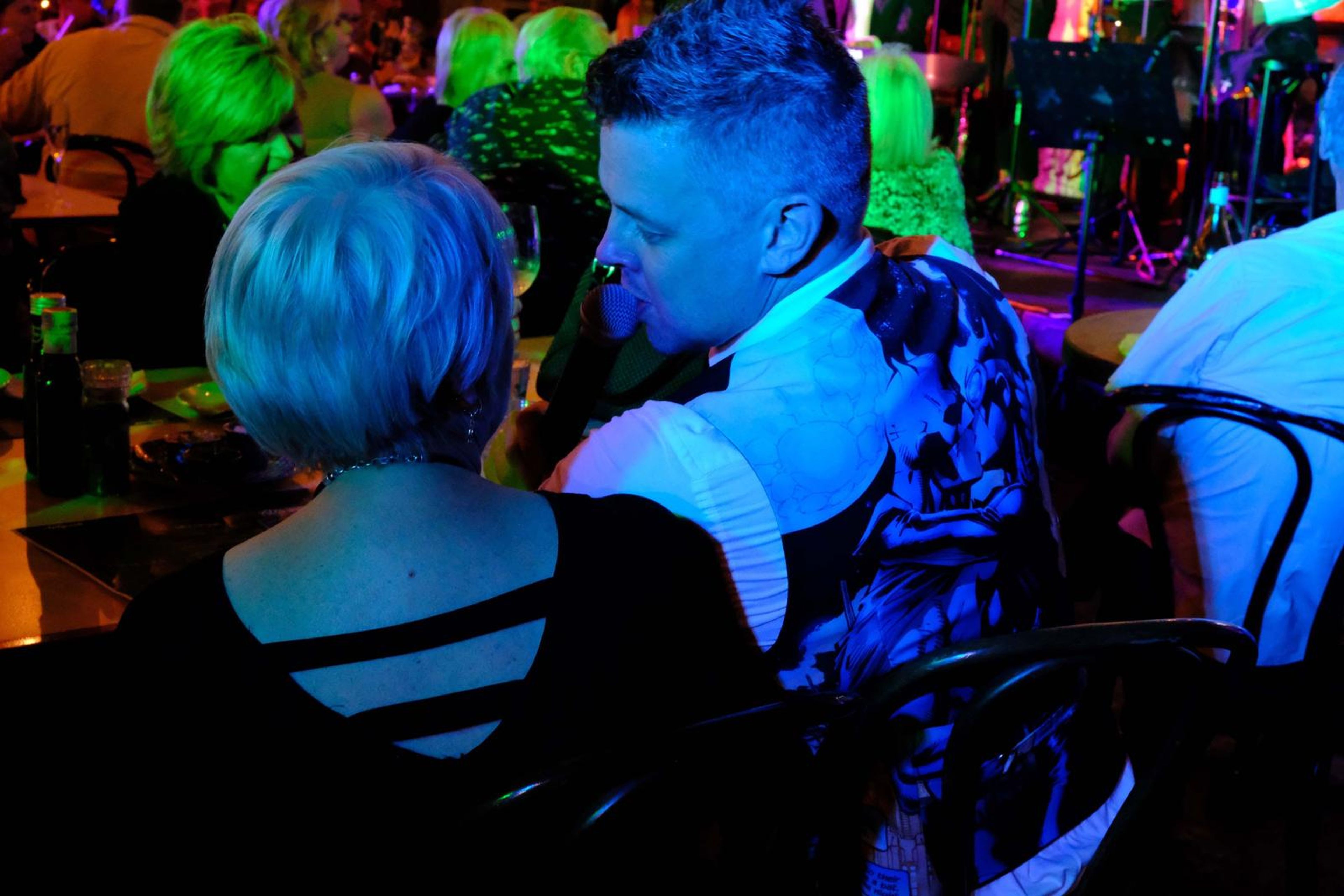 Singer singing into a guest's ear at a table